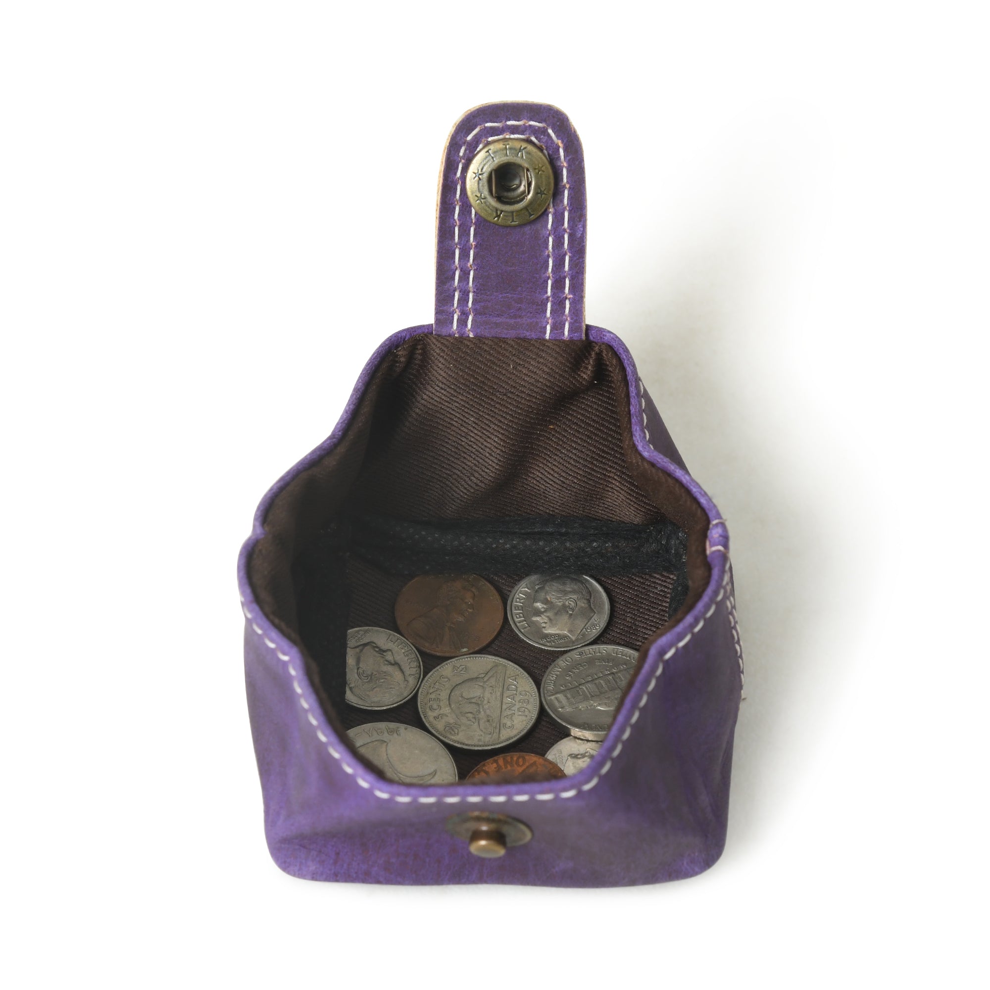 Open purple leather coin purse with snap closure, showcasing its interior filled with various coins.