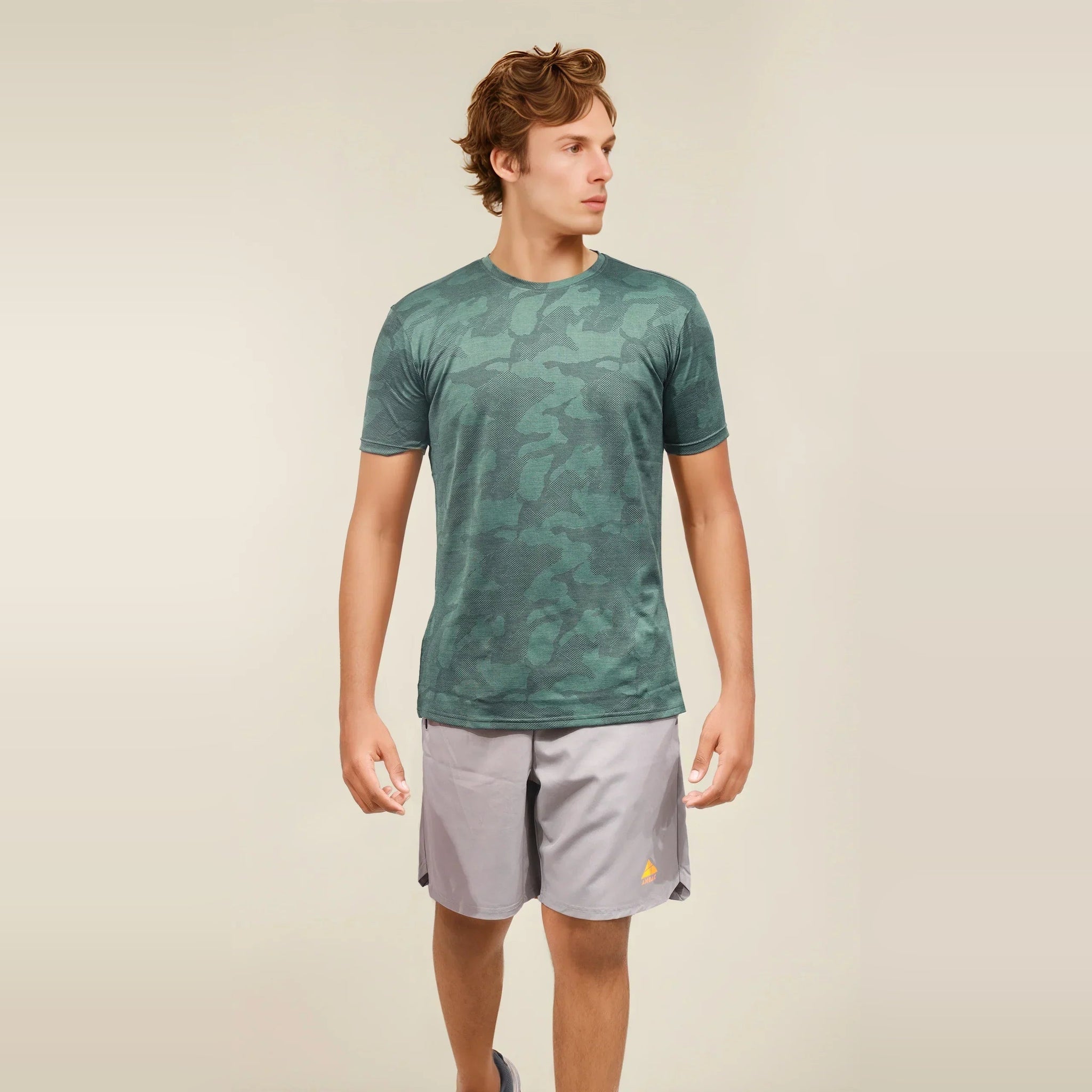 Man wearing a green camo, dry-fit, crew neck t-shirt designed for workouts. Ã‚