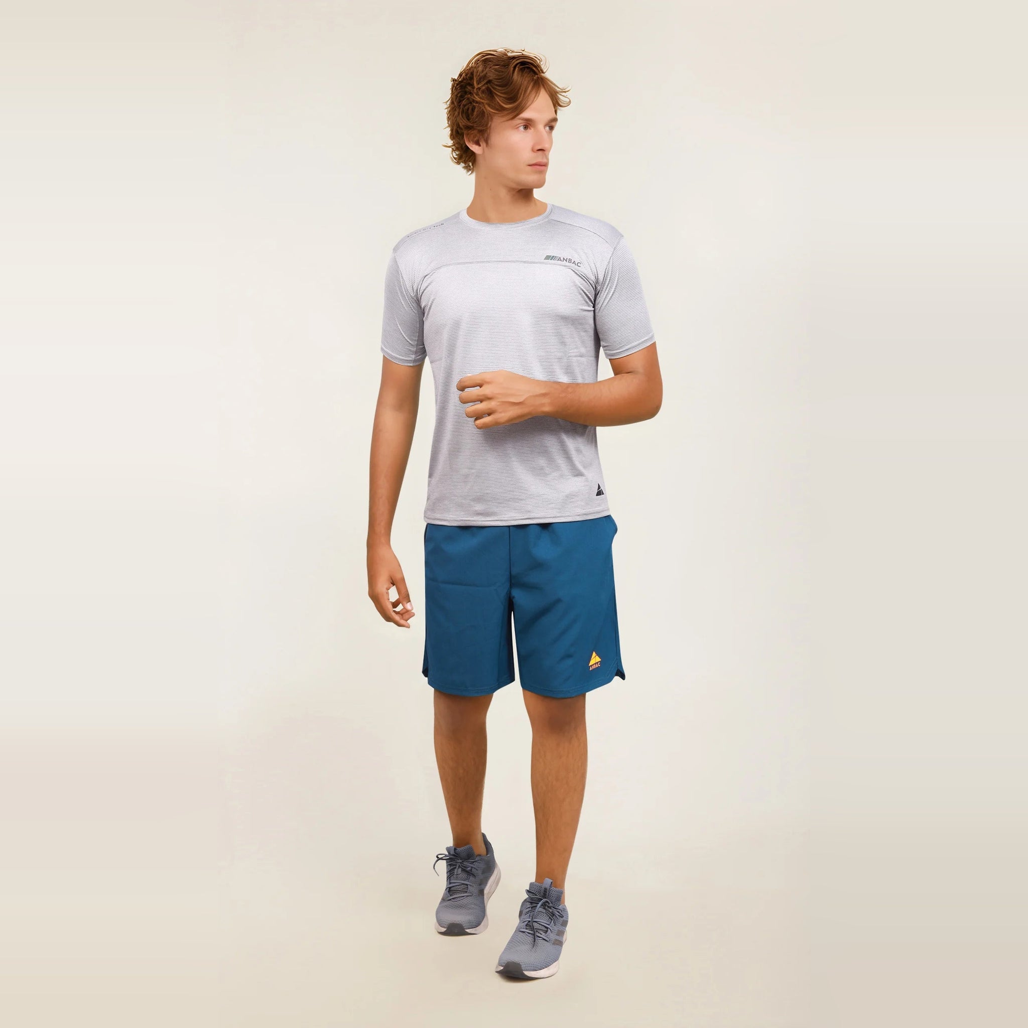 Man modeling a slim-fit, short sleeve, athletic t-shirt in gray.