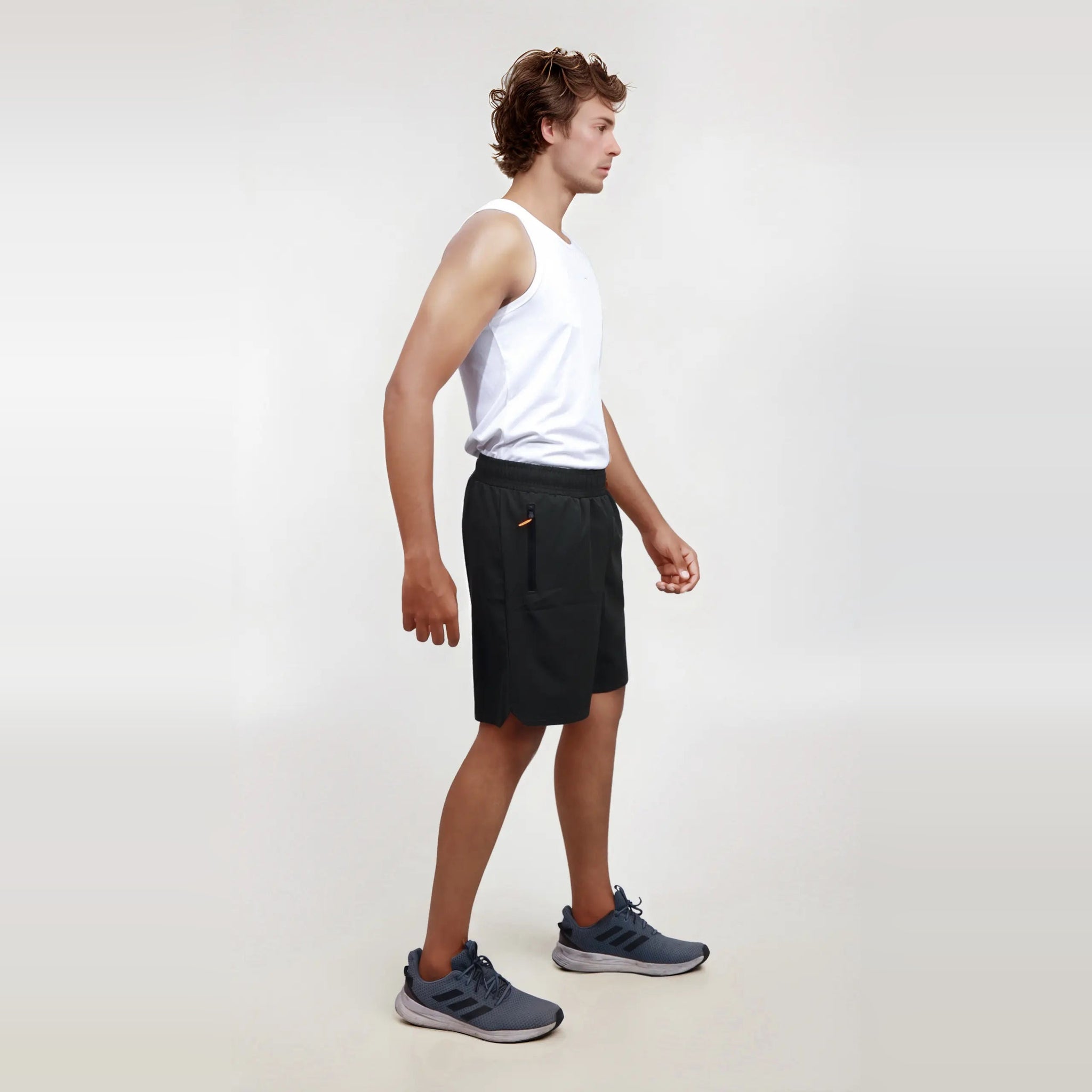 Man wearing wrinkle-free, dry-fit black shorts for sports and gym.