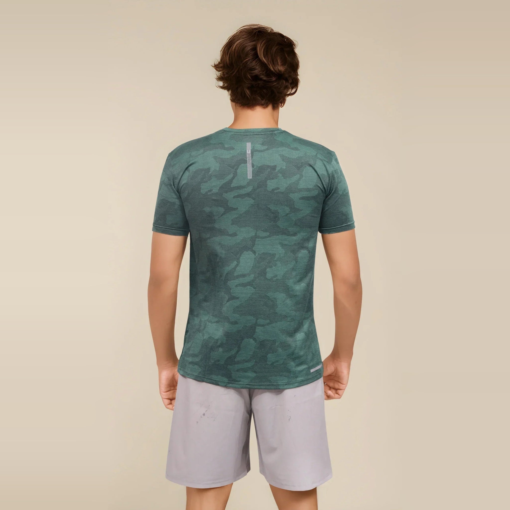 Man wearing a green camo Dry-Fit crew neck t-shirt from the back, showcasing its breathable fabric ideal for workouts.