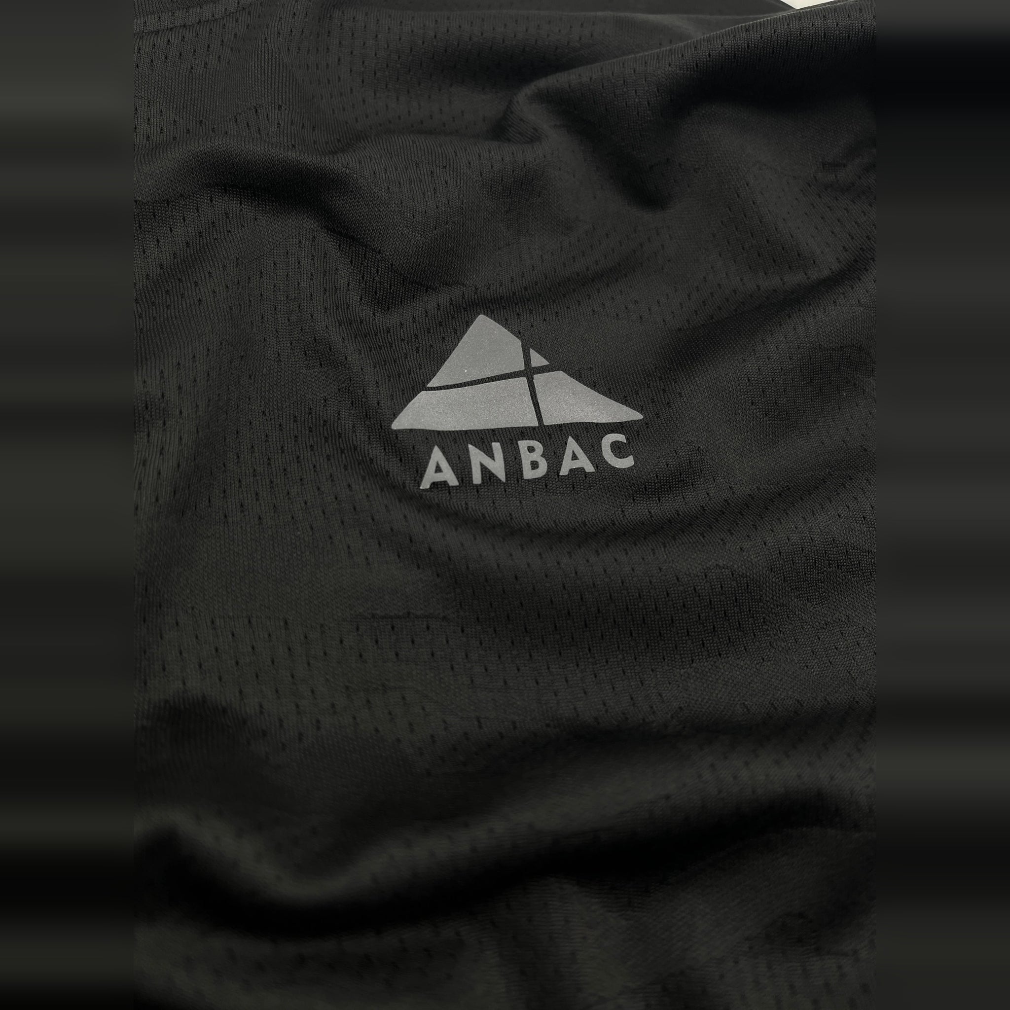 Close-up of the breathable, dry-fit fabric of a black ANBAC men's crew neck workout t-shirt.