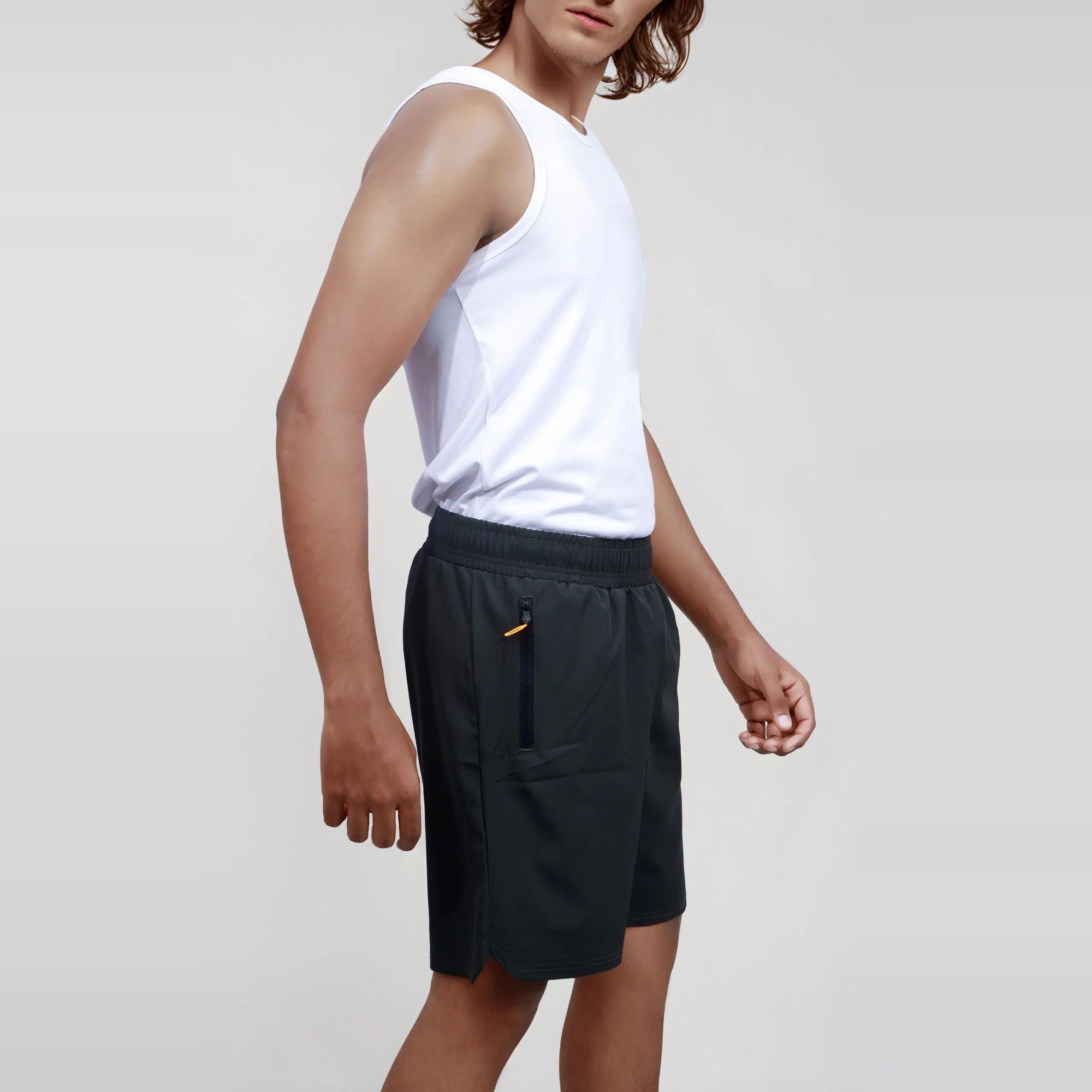 Man wearing black wrinkle-free, dry-fit shorts ideal for sports and gym workouts.