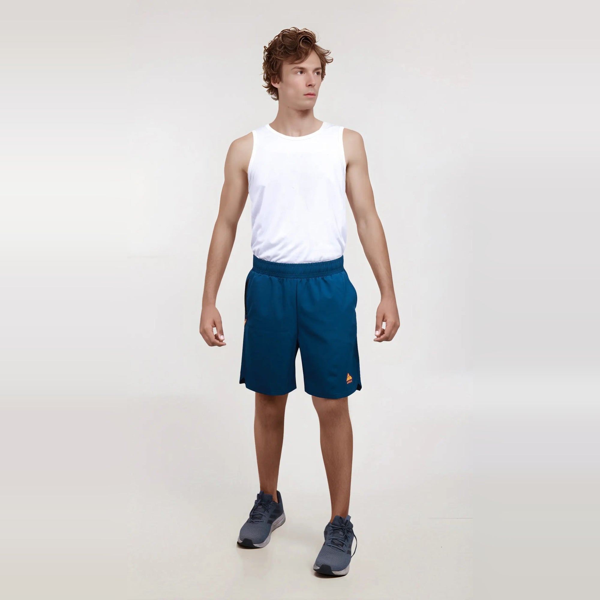 Man modeling navy blue men's regular fit workout shorts, showcasing their wrinkle-free, dry-fit design.