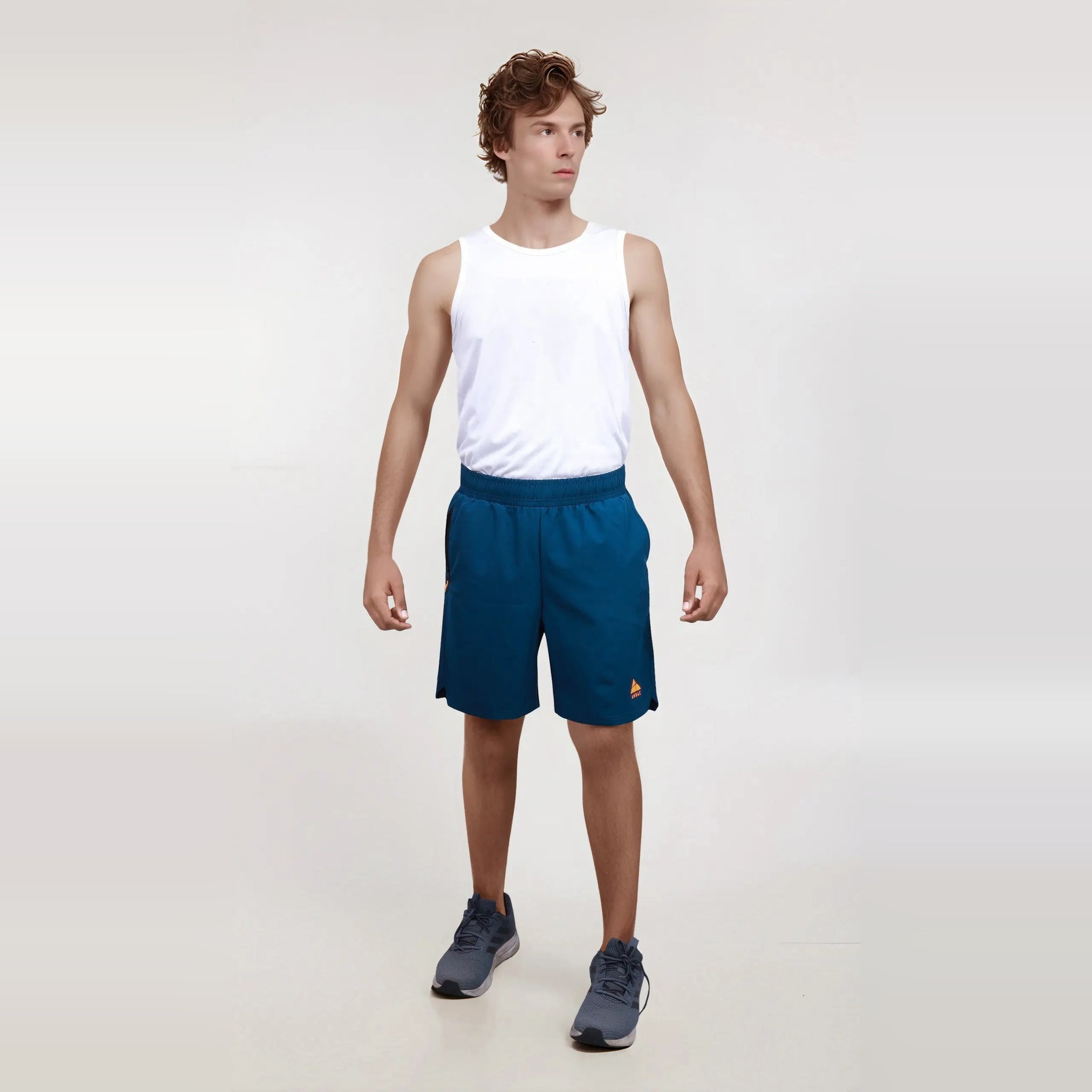 Man modeling navy blue men's regular fit workout shorts, showcasing their wrinkle-free, dry-fit design.