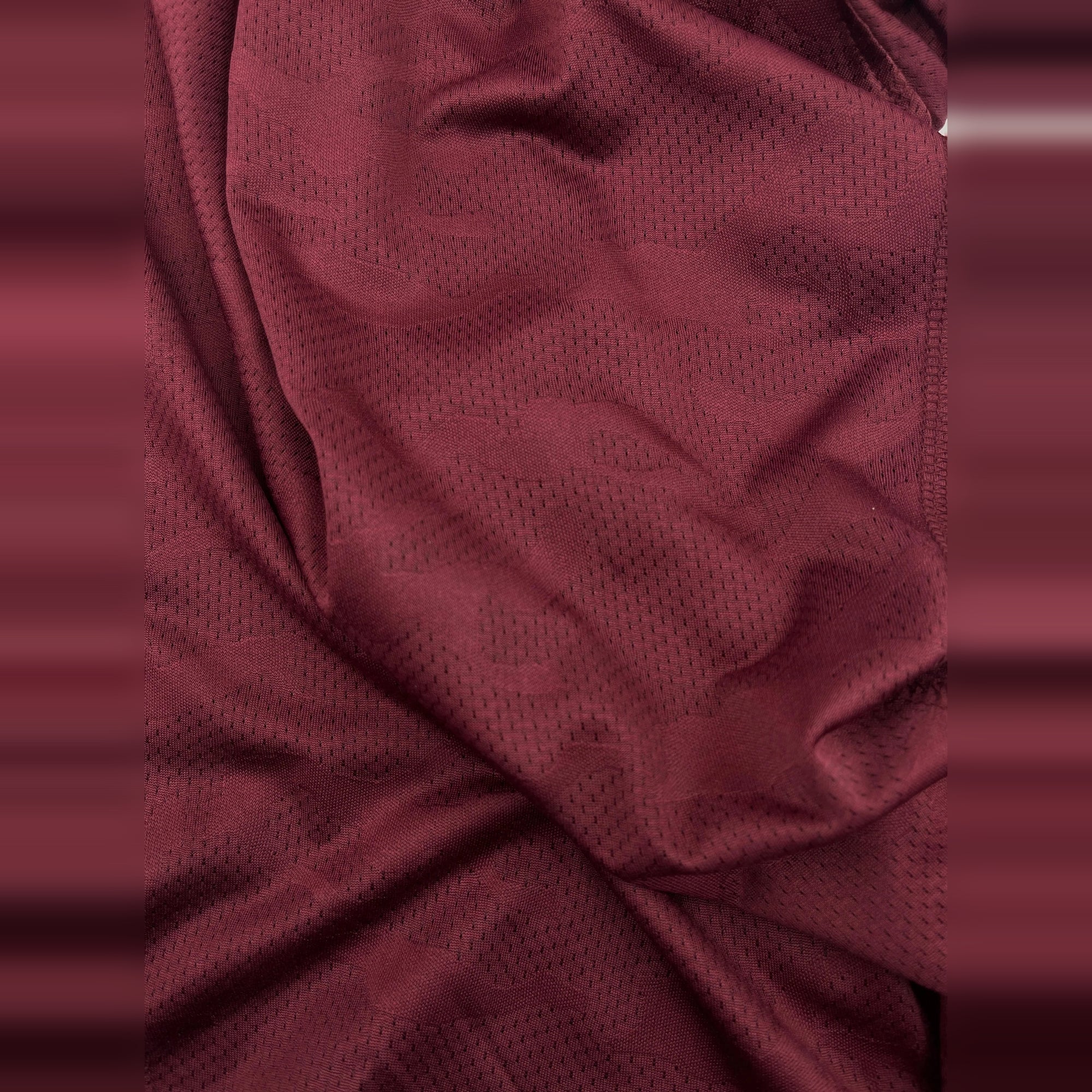 Close-up of breathable, maroon Dry-Fit fabric. This men's crew neck t-shirt is perfect for workouts.