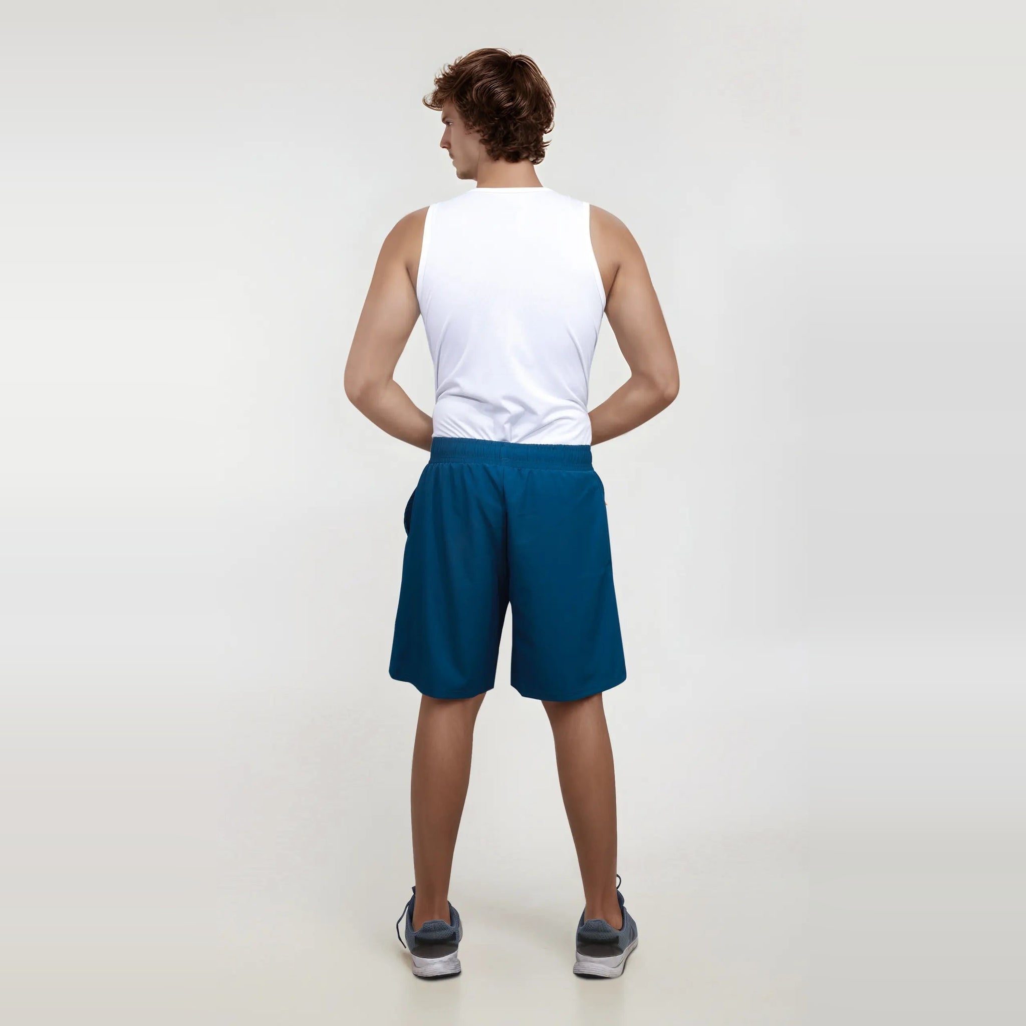 Man wearing wrinkle-free, dry-fit blue shorts for sports and gym.