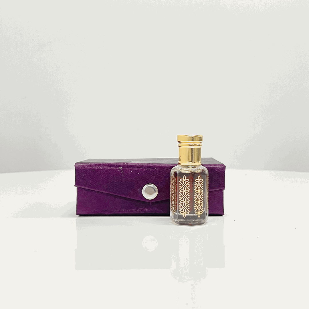 A bottle of Bakhoor Attar Unisex fragrance in an ornate glass bottle with gold detailing, presented in a luxurious purple velvet box.