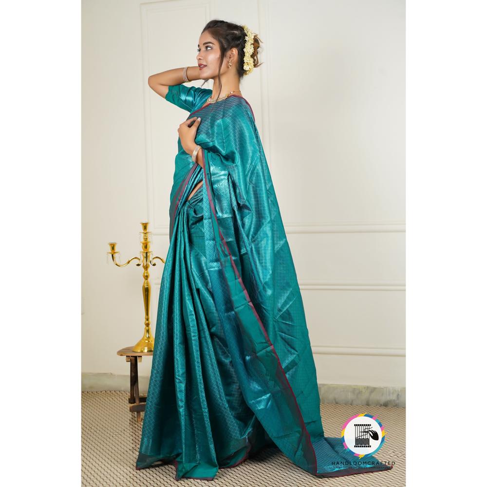 A woman models a dark blue Banarasi tissue silk saree with a subtle print, showcasing its drape and sheen.