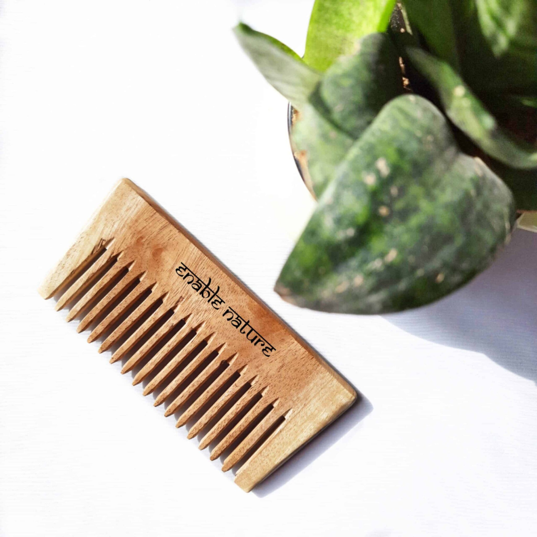 Handmade neem wood comb with wide teeth for gentle detangling and promoting healthy hair.