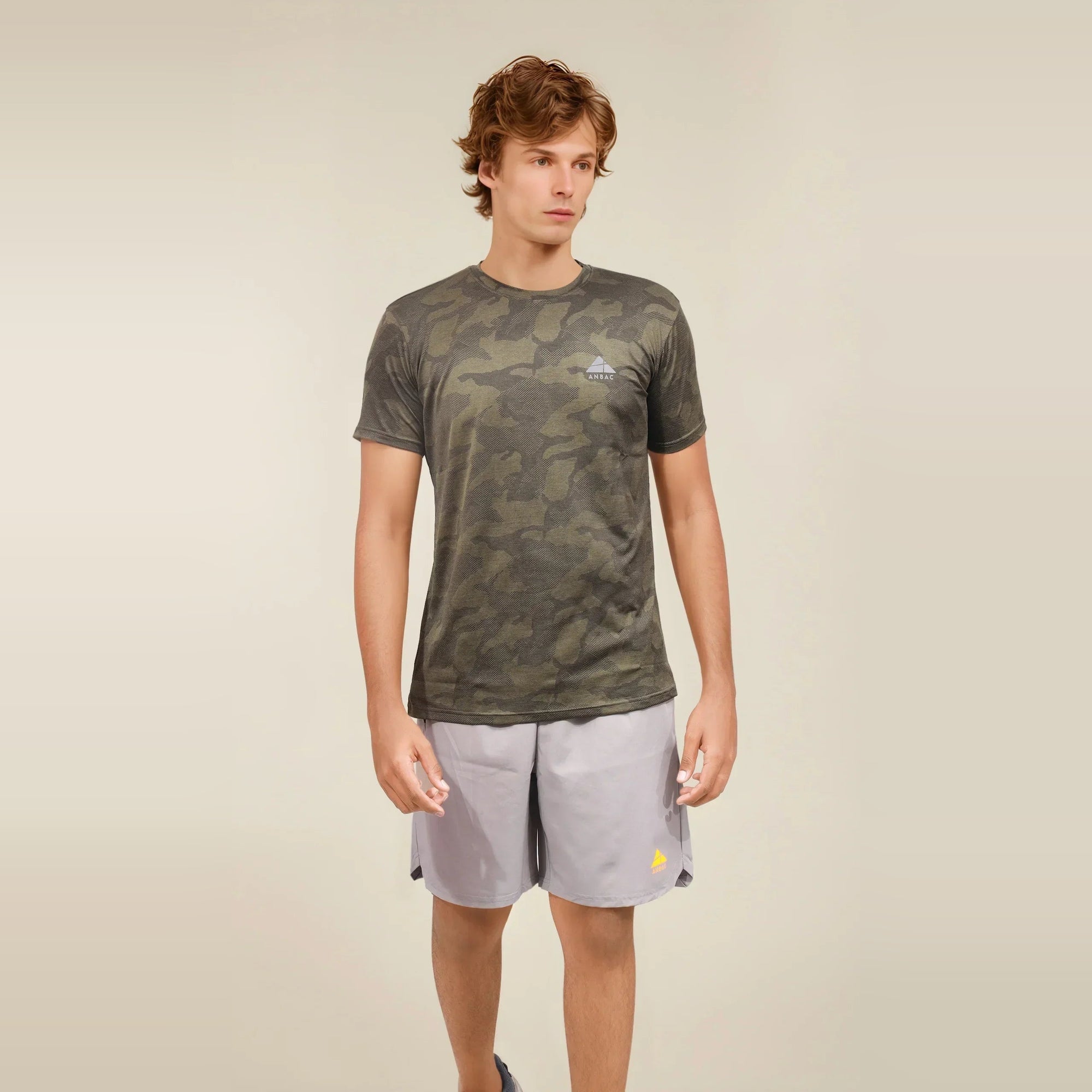 Man wearing a green camouflage, dry-fit, crew neck t-shirt, ideal for workouts.