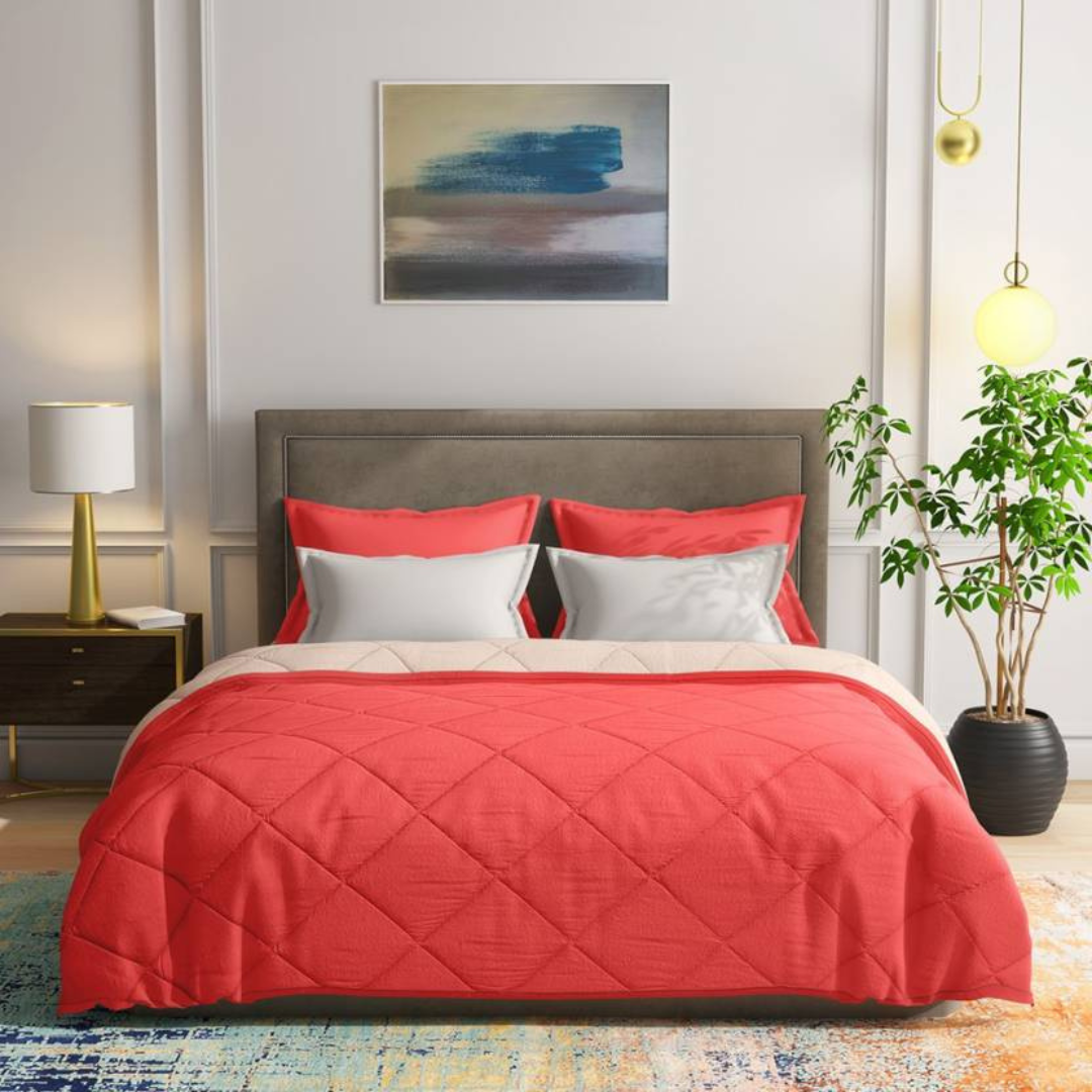 A coral Bellolin Microfibre Reversible Comforter shown neatly arranged on a bed. This lightweight, breathable comforter provides soft comfort and is perfect for a double bed.