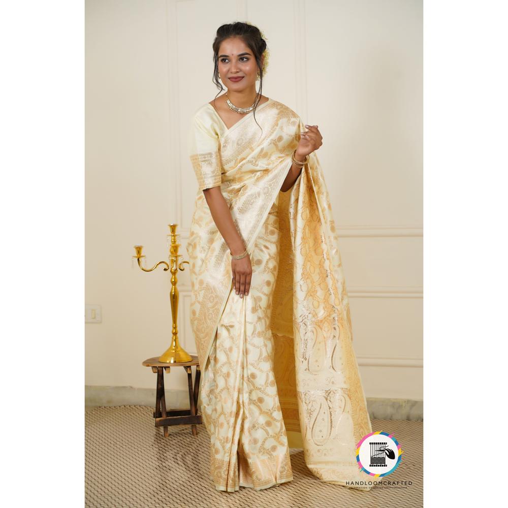 A model wears a Parmigiano Cheese color Banarasi Tissue Silk Saree with intricate gold floral designs, highlighting the elegance and drape of the fabric.