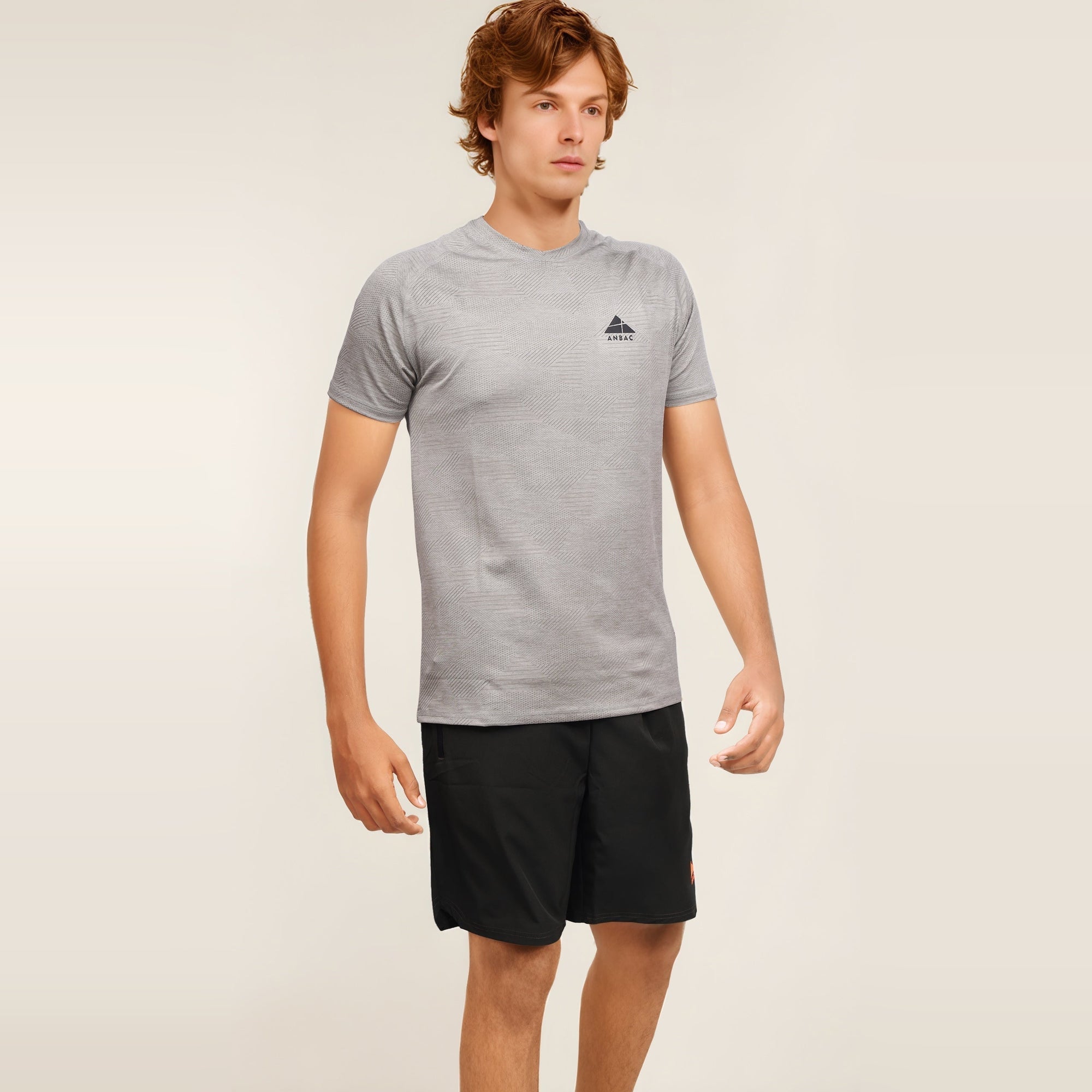 Man in a gray textured, dry-fit, short sleeve crew neck t-shirt, perfect for workouts or casual wear.