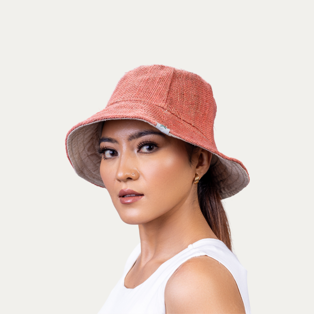 Woman modeling a stylish, breathable hemp bucket hat in a natural red color. This hat offers UV protection and easy airflow for comfort.