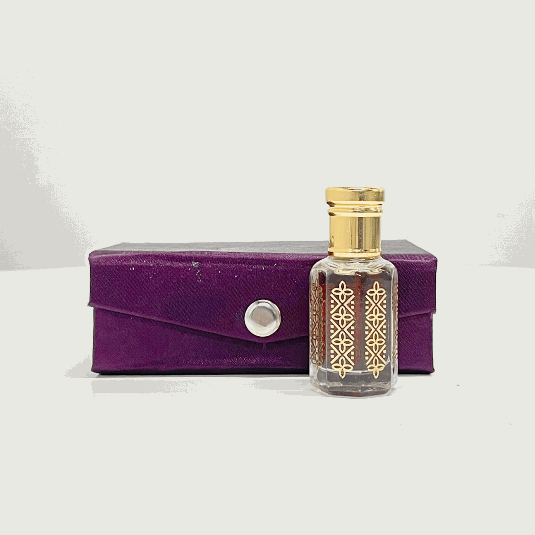 A bottle of Black Oud Attar unisex fragrance with a gold top, beside a purple presentation box.