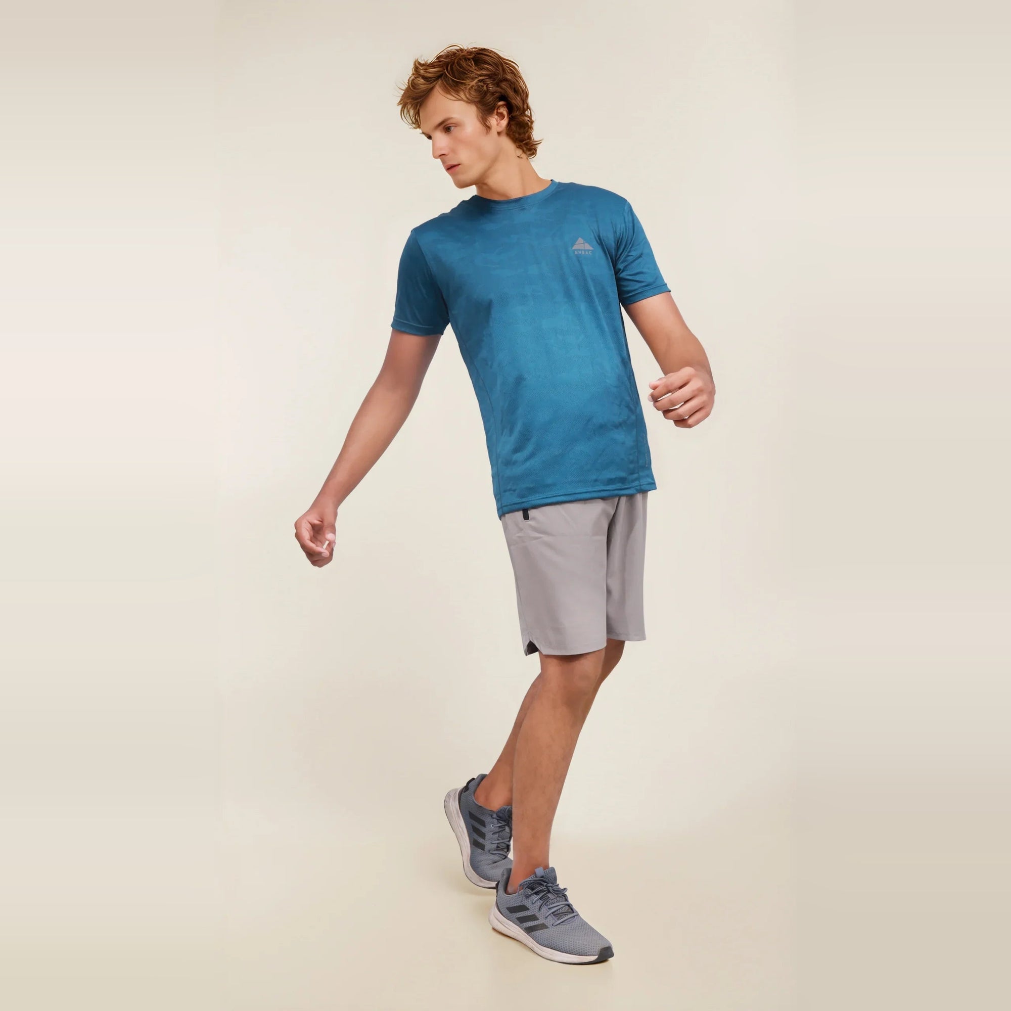 Man wearing a blue crew neck dry-fit t-shirt, ideal for workouts and athletic activities.