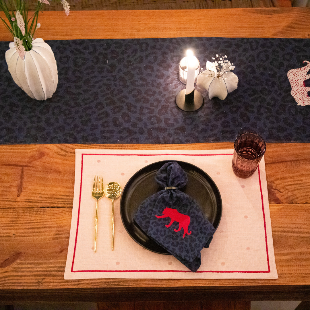 Stylish navy blue cotton table runner with a red tiger embroidery, adding a touch of elegance to a dining table setting.