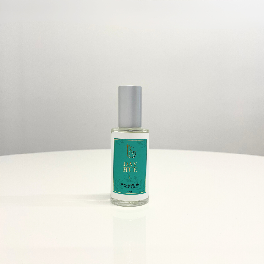 A bottle of The Day's Hue Perfume, a unisex fragrance, with a teal and gold label. Hand-crafted.