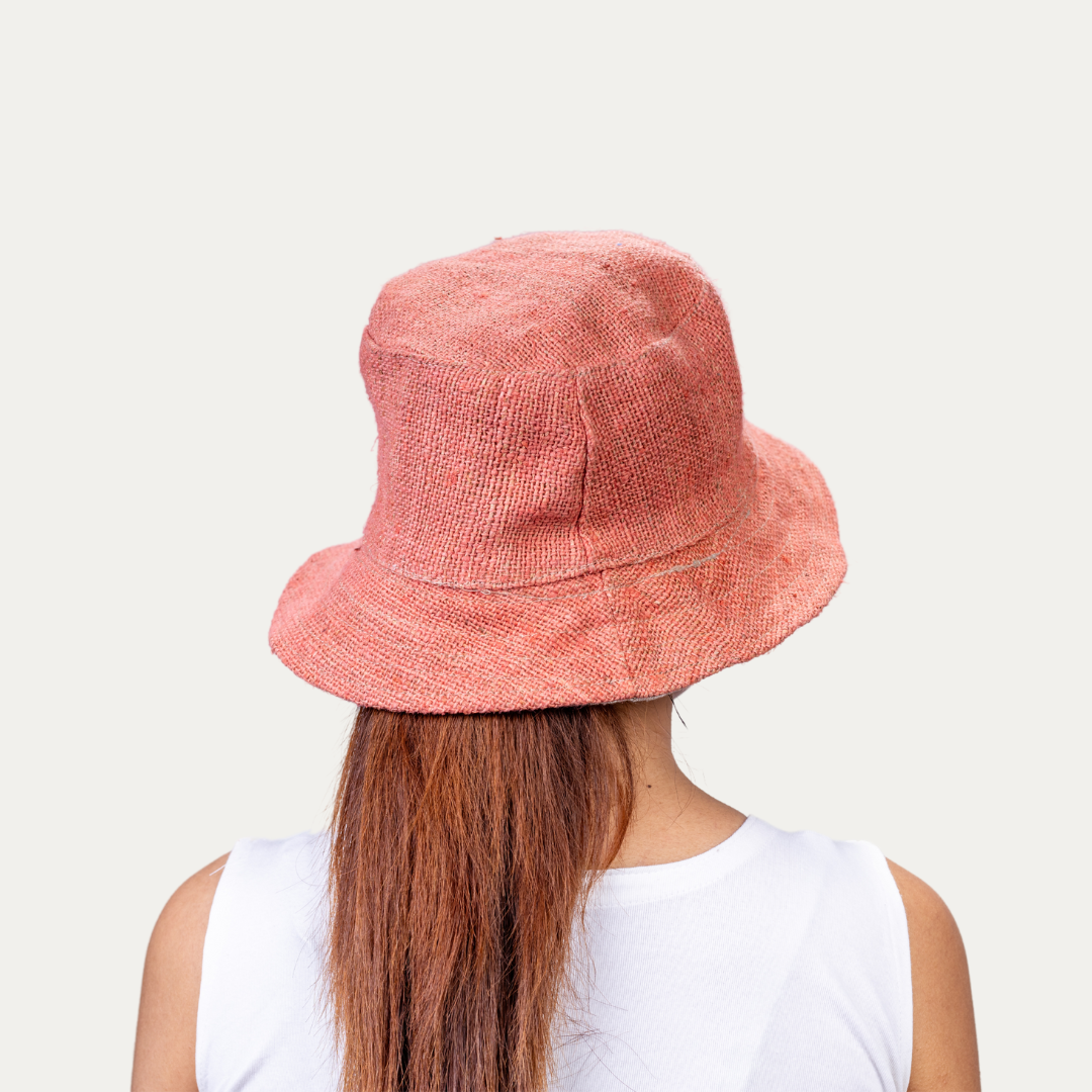 Woman wearing a stylish, breathable hemp bucket hat in a natural tone. Provides UV protection and airflow for comfort on sunny days.