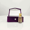 Black Oud Attar in an ornate glass bottle, nestled in a luxurious purple velvet presentation box.