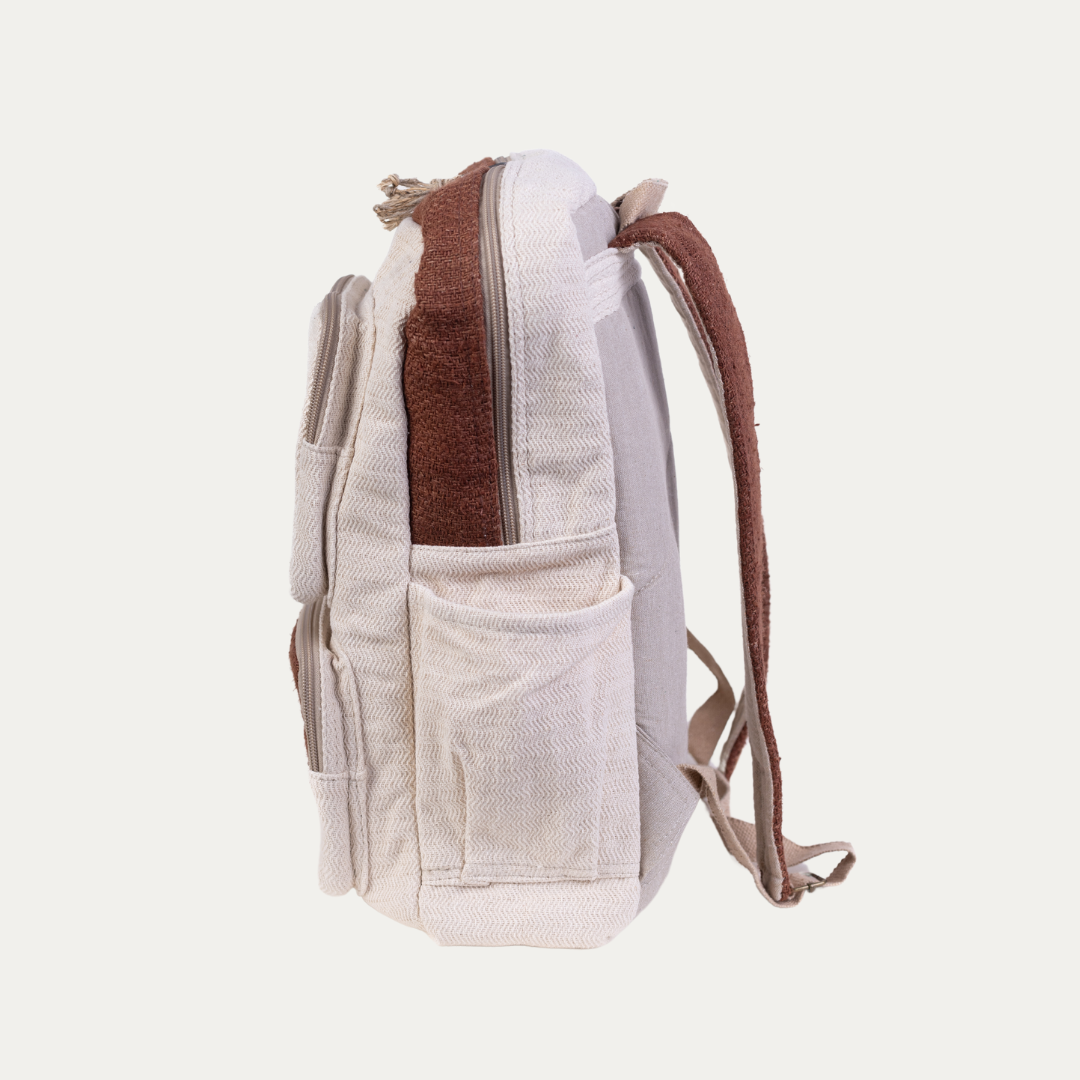 Side view of a cream and brown handmade hemp backpack with multiple pockets, highlighting its spacious and eco-friendly design.