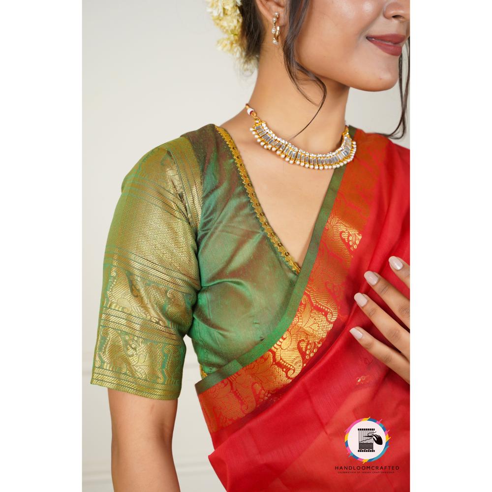 Woman wearing a green and red Banarasi tissue silk saree with intricate gold patterns.