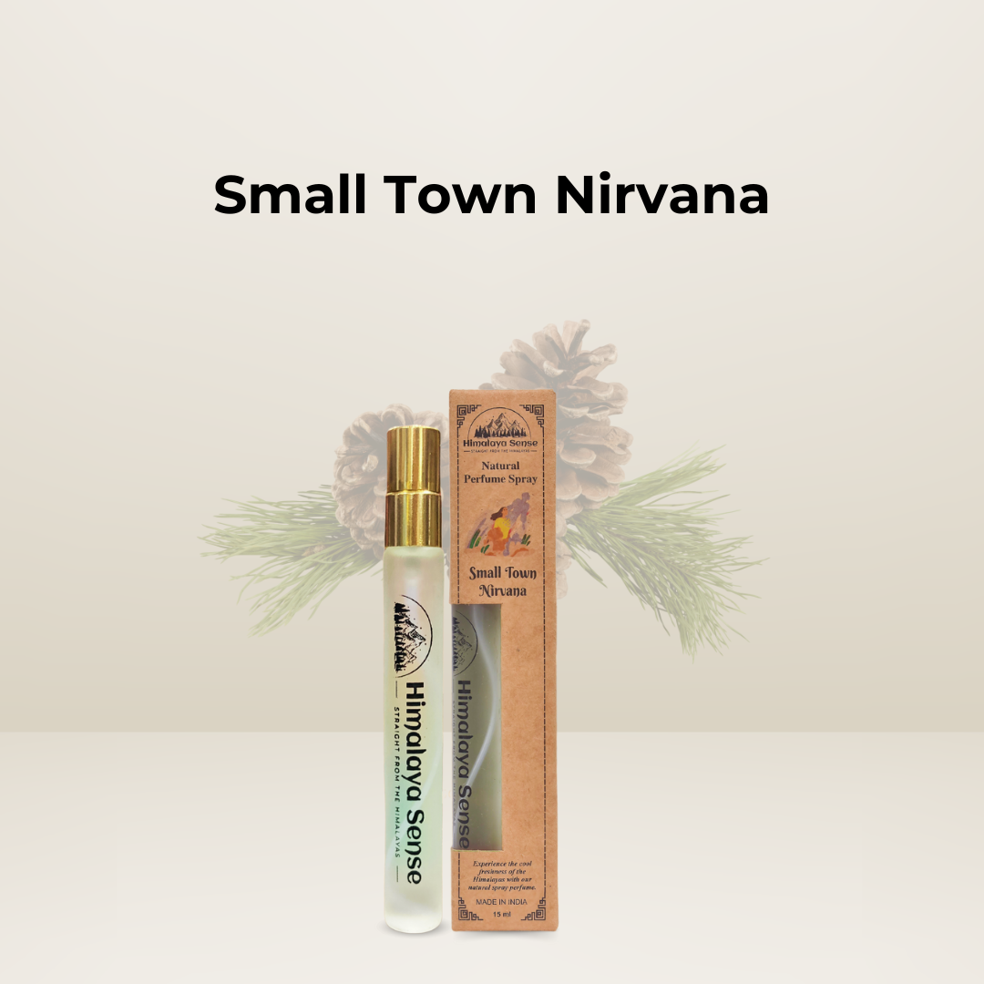 A bottle of Small Town Nirvana natural perfume spray, by Himalaya Sense, against a natural, woodsy background.