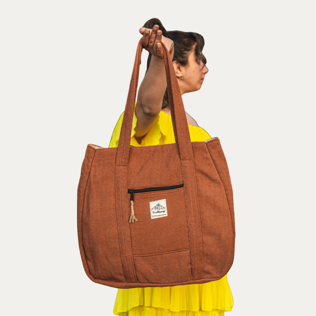 Woman holding a rust-colored Himalayan Hemp Tote Shoulder Bag, showcasing its spacious design and durable hemp construction.