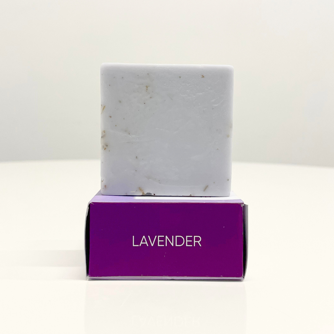 Handcrafted lavender soap bar on top of purple branded box.