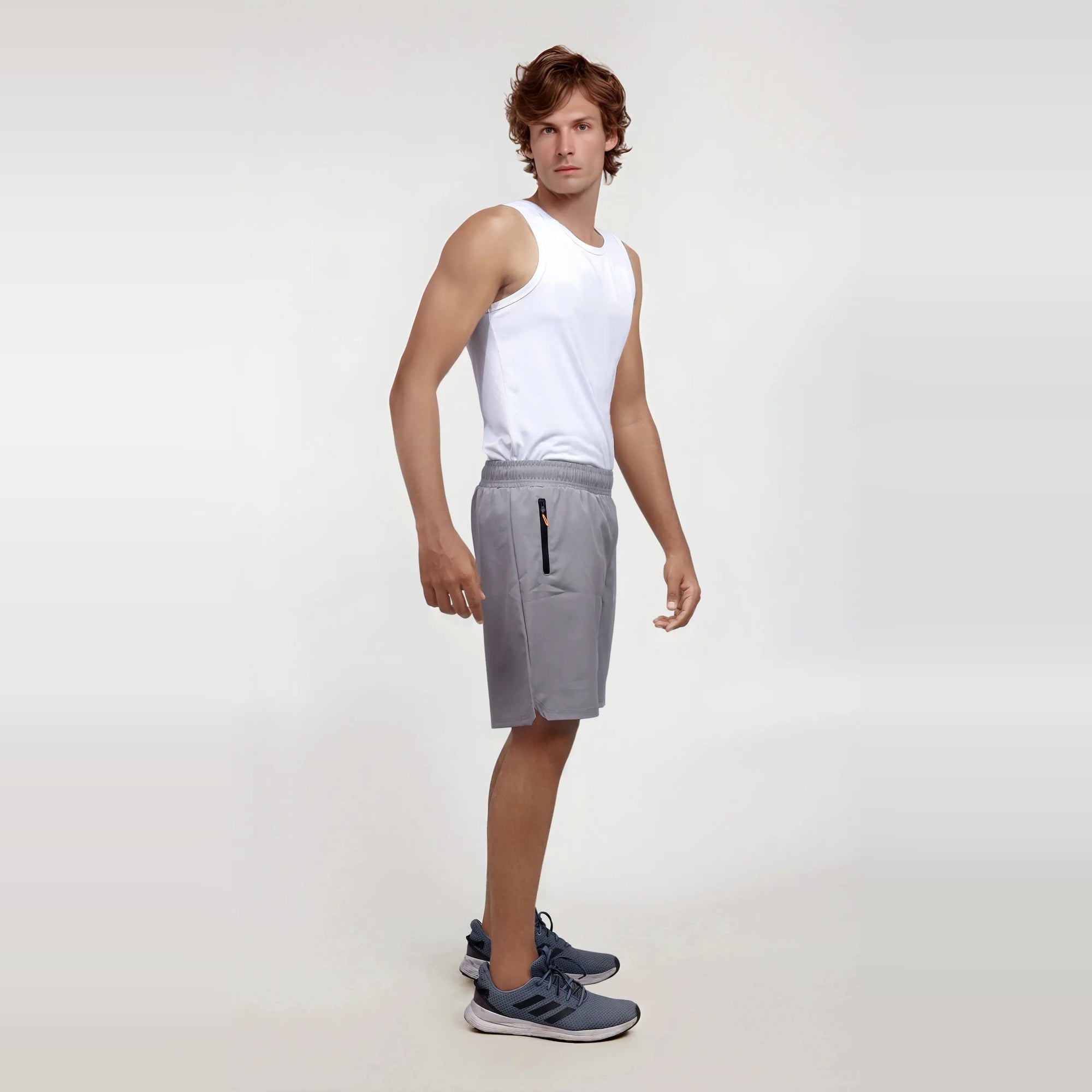 Man wearing wrinkle-free, dry-fit, regular fit grey shorts ideal for sports and the gym.