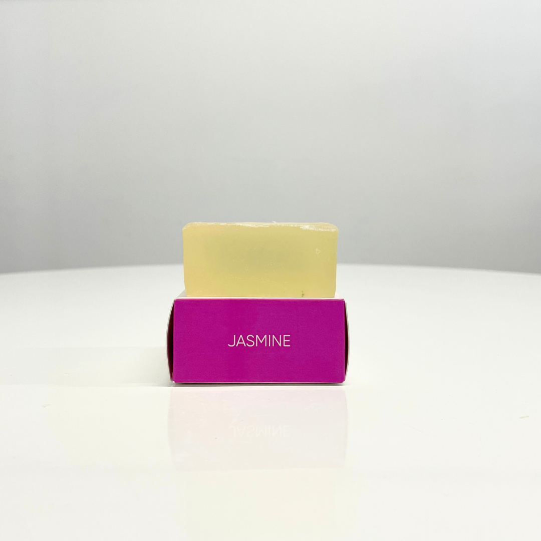 A single bar of handcrafted Jasmine soap rests on its bright pink box.