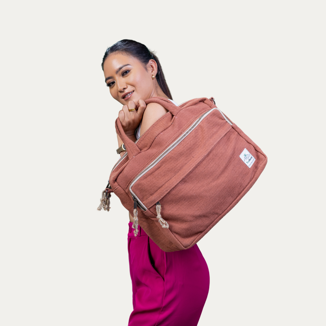 Stylish woman carries a spacious, terracotta "Handmade Natural Hemp Side Bag with Cotton Blend" featuring zippered compartments and a comfortable strap.