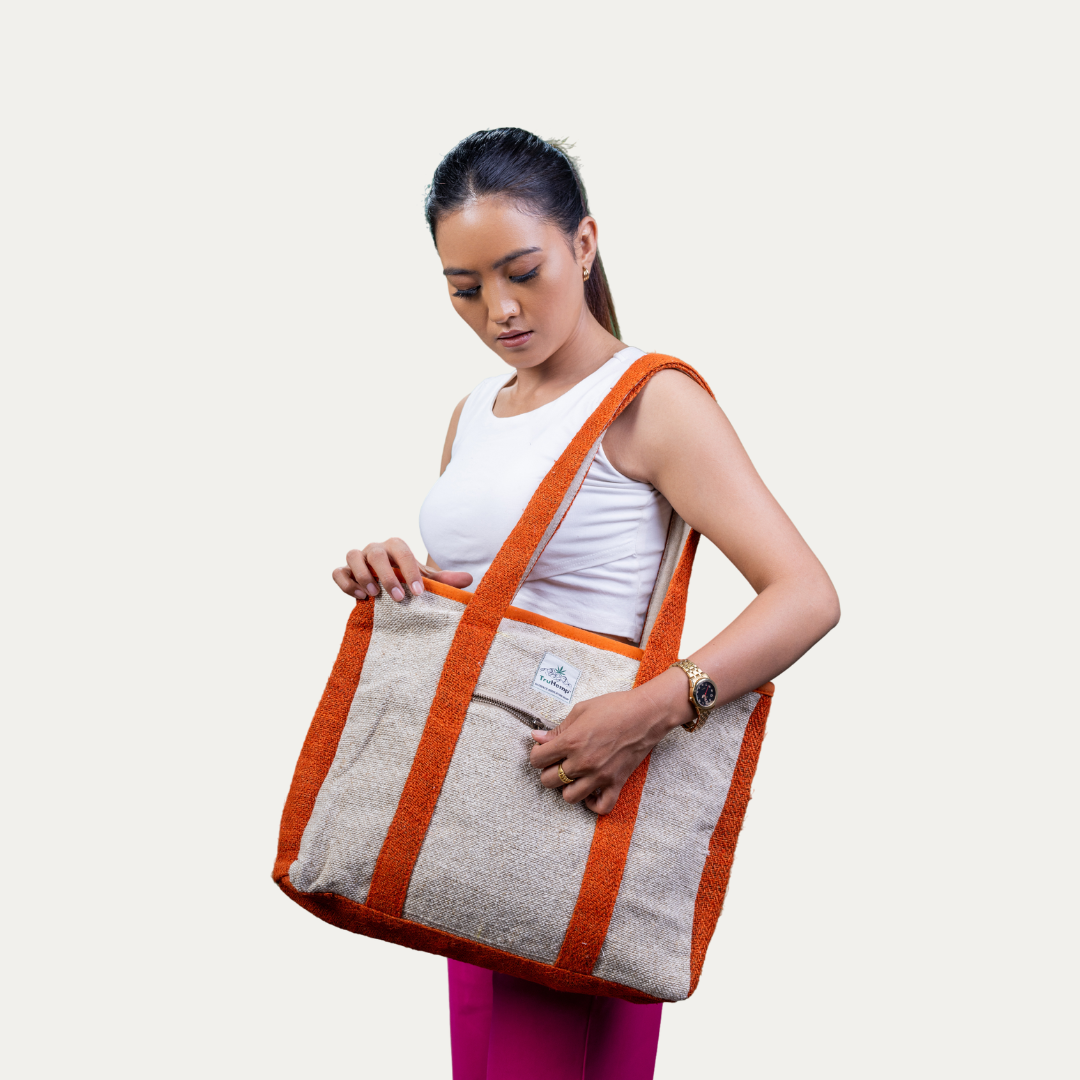 A woman models a spacious, eco-friendly hemp tote bag with orange accents, perfect for corporate settings.