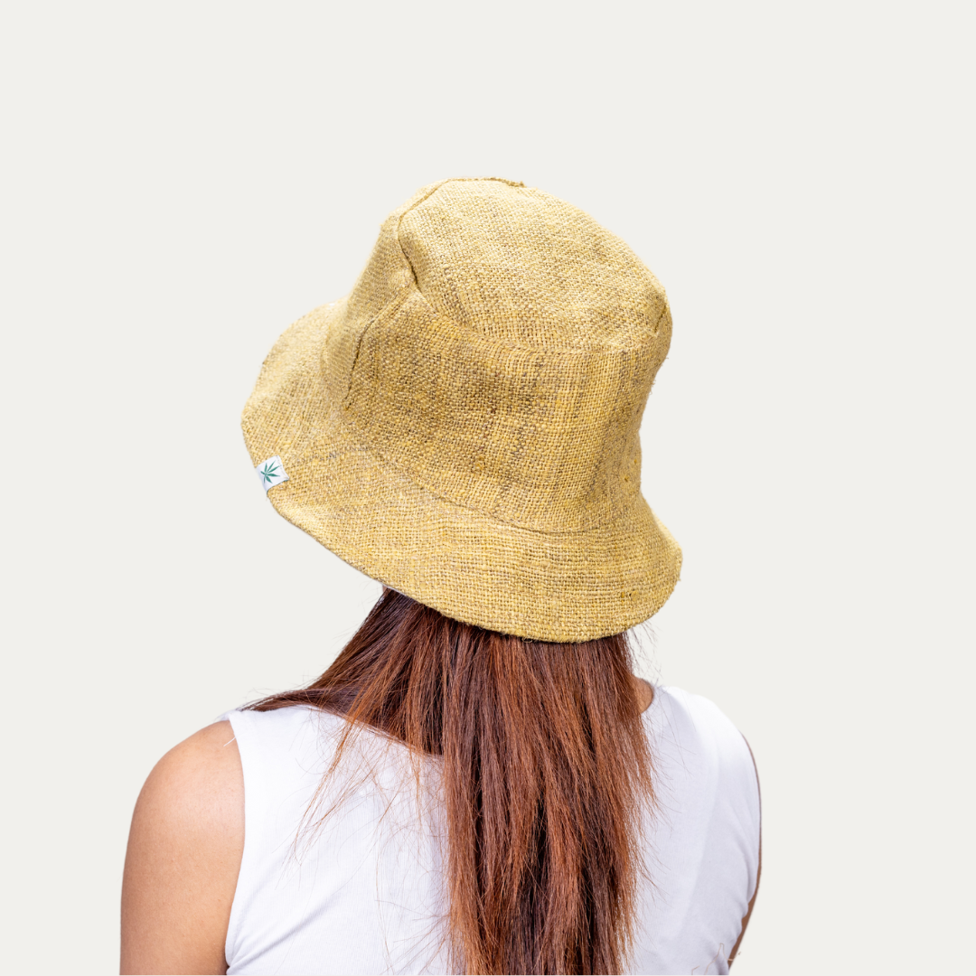 Woman wearing a stylish yellow hemp bucket hat, offering UV protection and breathable comfort.