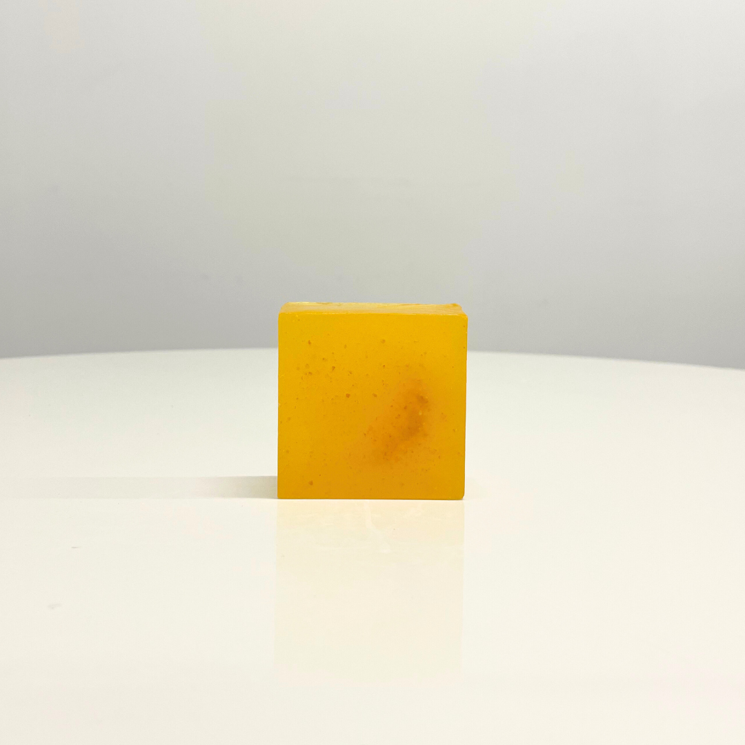 A single bar of bright yellow, handcrafted Sweet Lime Soap sits on a white surface.