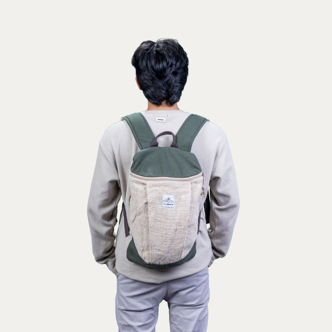 Man wearing a handcrafted hemp backpack with a green top flap and a pure cotton lining, showcasing its stylish design and sustainable materials.