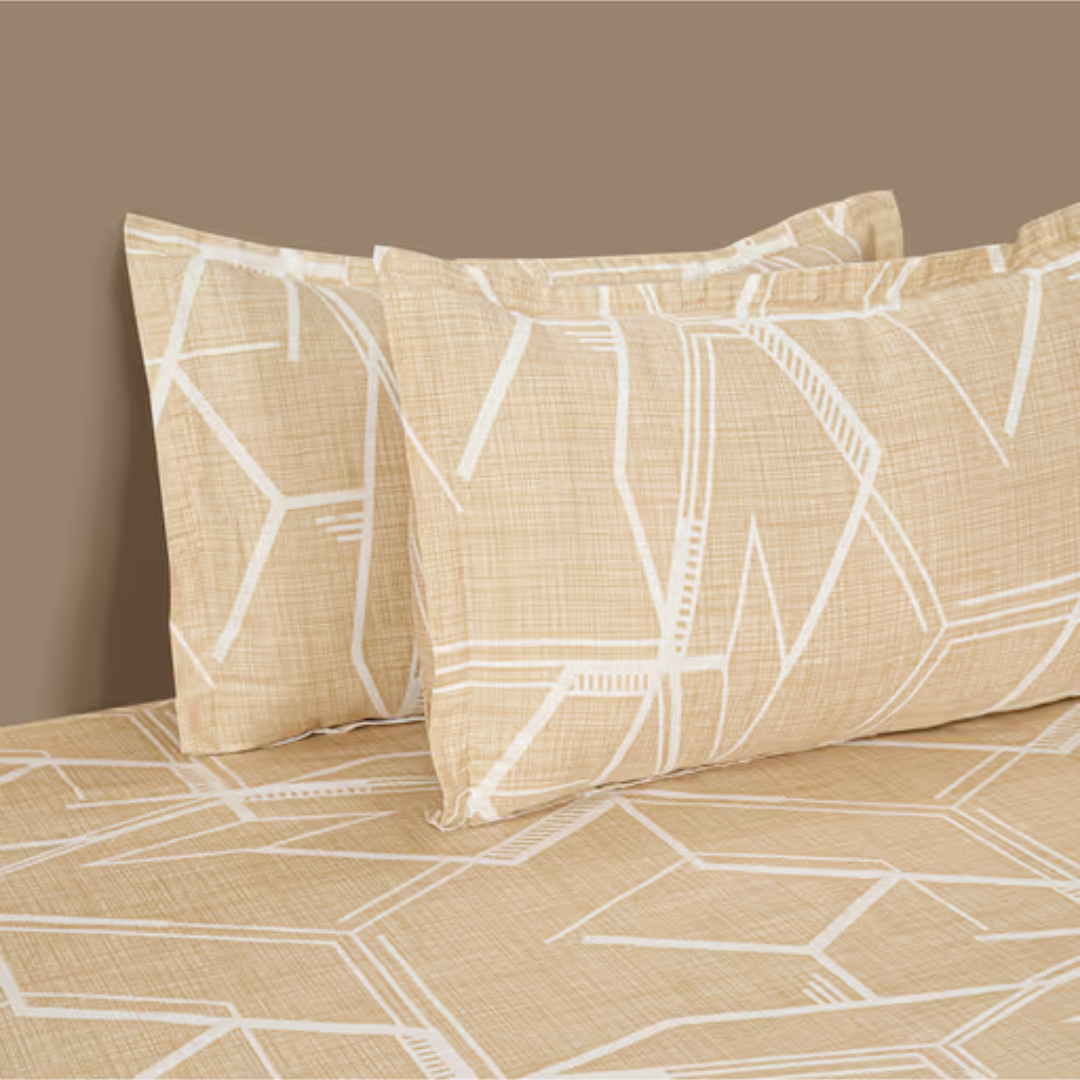 Tan king size bedsheets with a modern white hexagonal geometric pattern. Two pillows are arranged on the made bed.