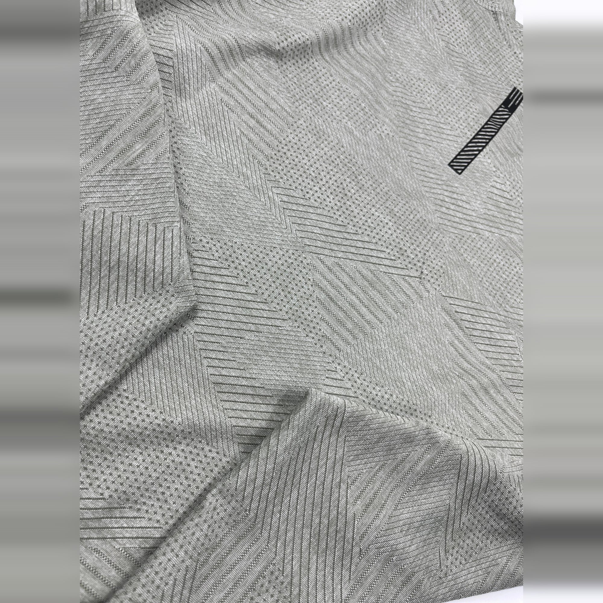 Close-up of heather grey Men's Short Sleeve Dry Fit Crew Neck T Shirt, featuring a subtle geometric pattern.