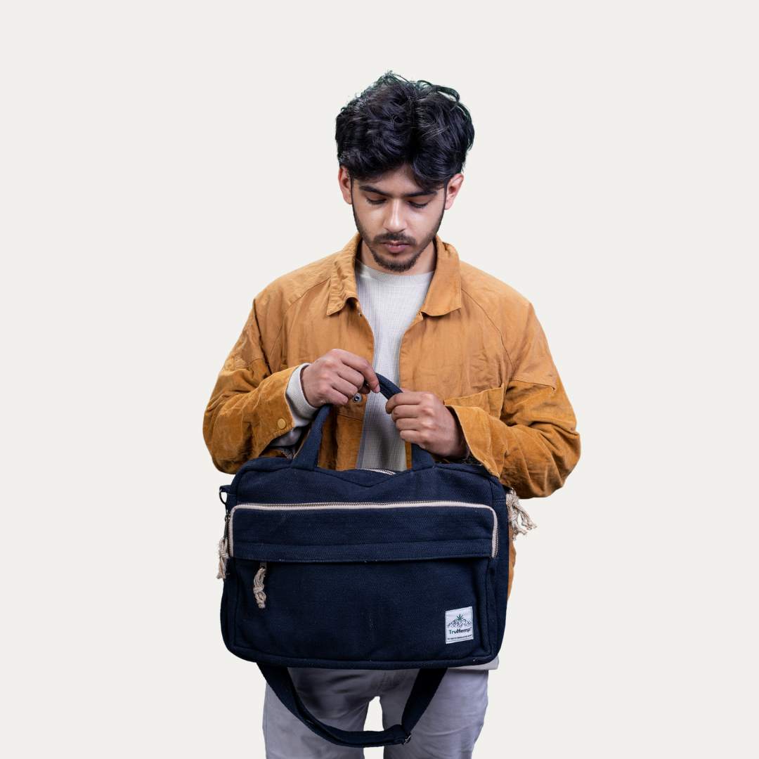 Stylish man holding a navy blue "Handmade Natural Hemp Side Bag with Cotton Blend", featuring a natural hemp strap and trim.