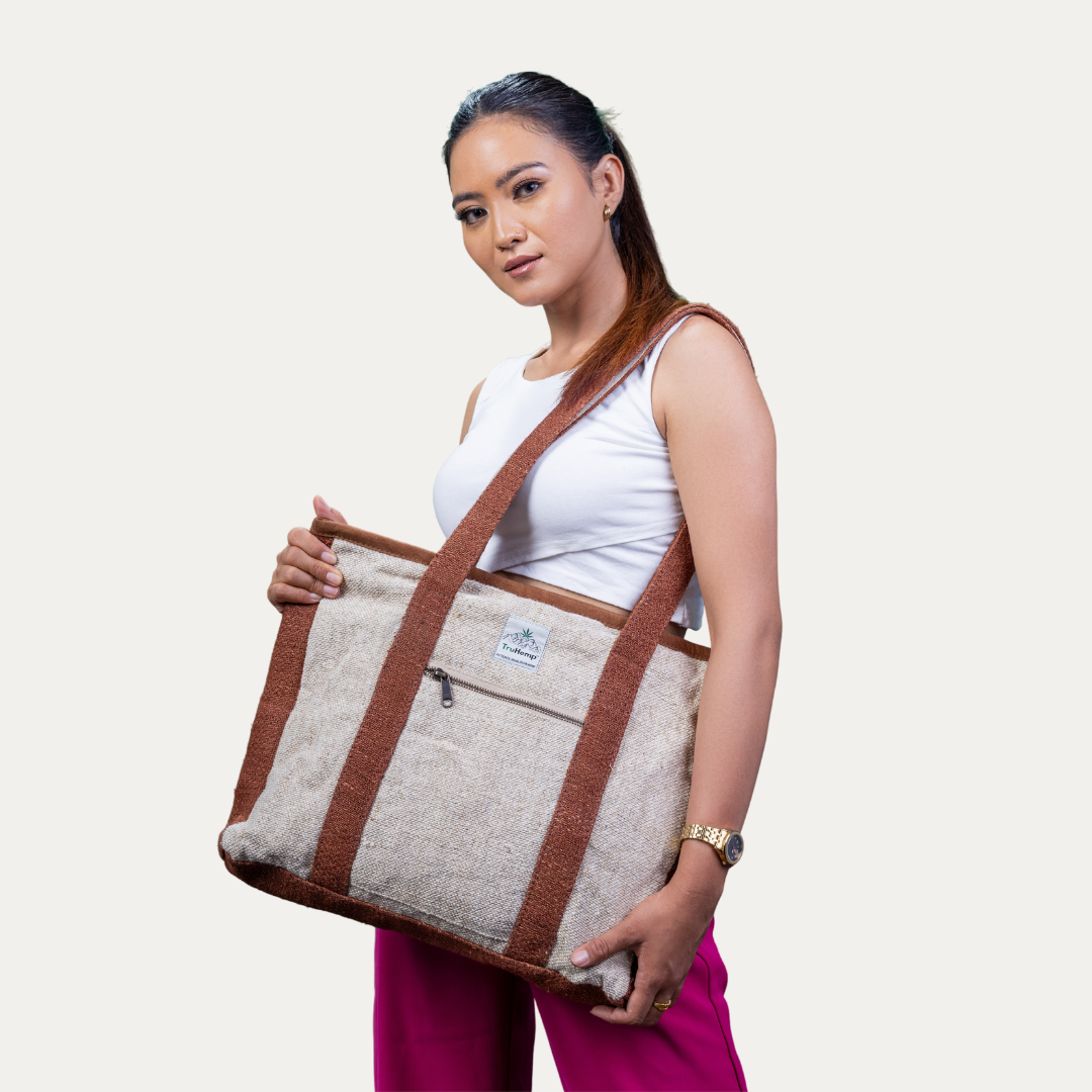 A woman models a spacious, eco-friendly hemp tote bag with brown trim, perfect for corporate settings or everyday use.