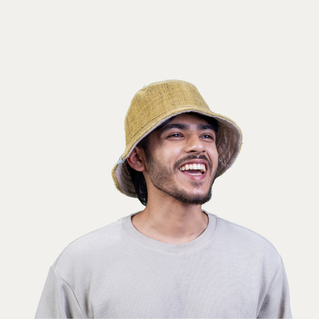 Man smiles wearing a stylish, yellow hemp bucket hat with UV protection and easy airflow.