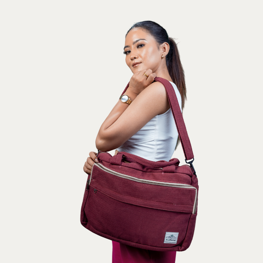 Stylish woman carries a maroon "Handmade Natural Hemp Side Bag with Cotton Blend", showcasing its spacious design and eco-friendly materials.