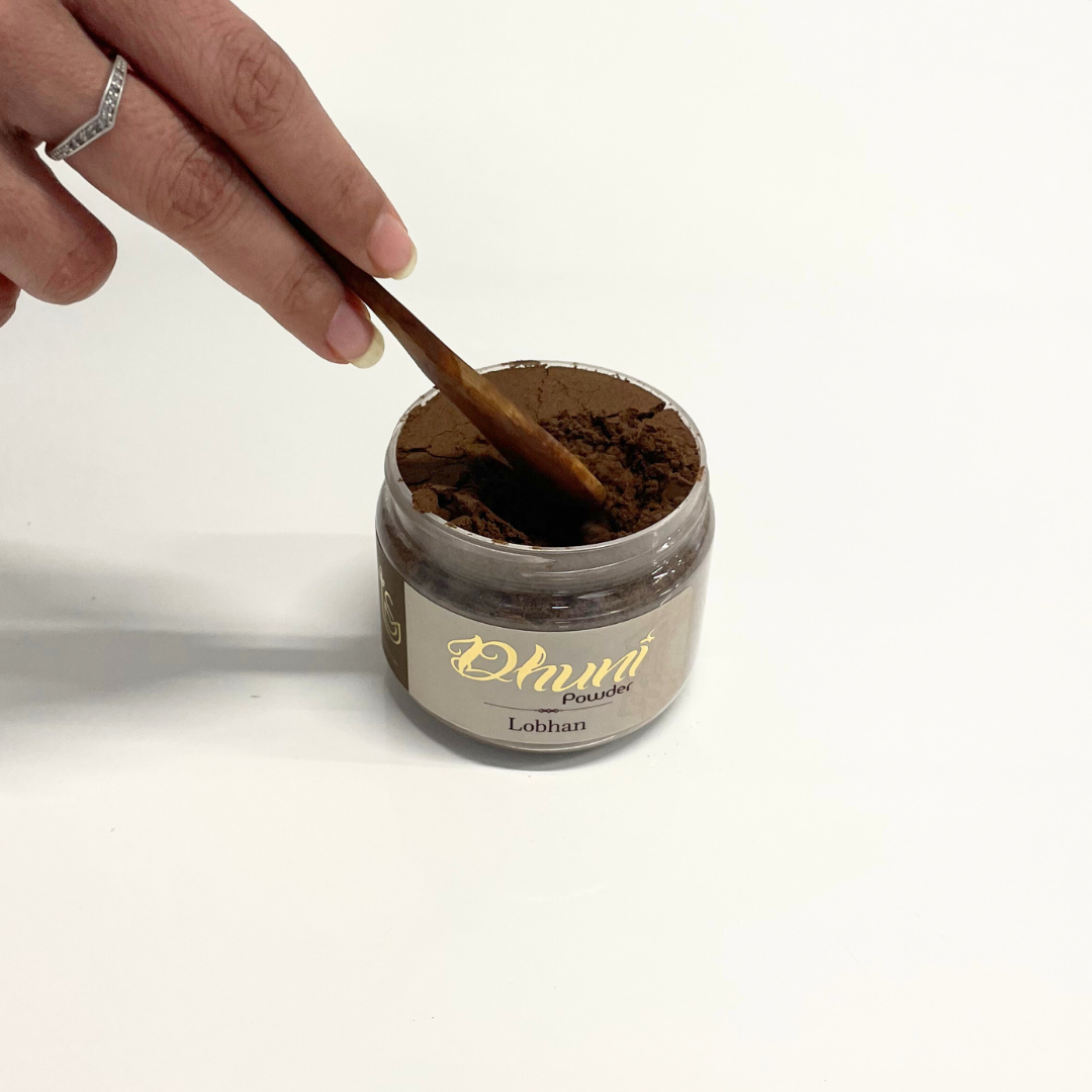 Jar of Dhuni Lobhan Powder with a wooden spoon scooping the aromatic resin powder.