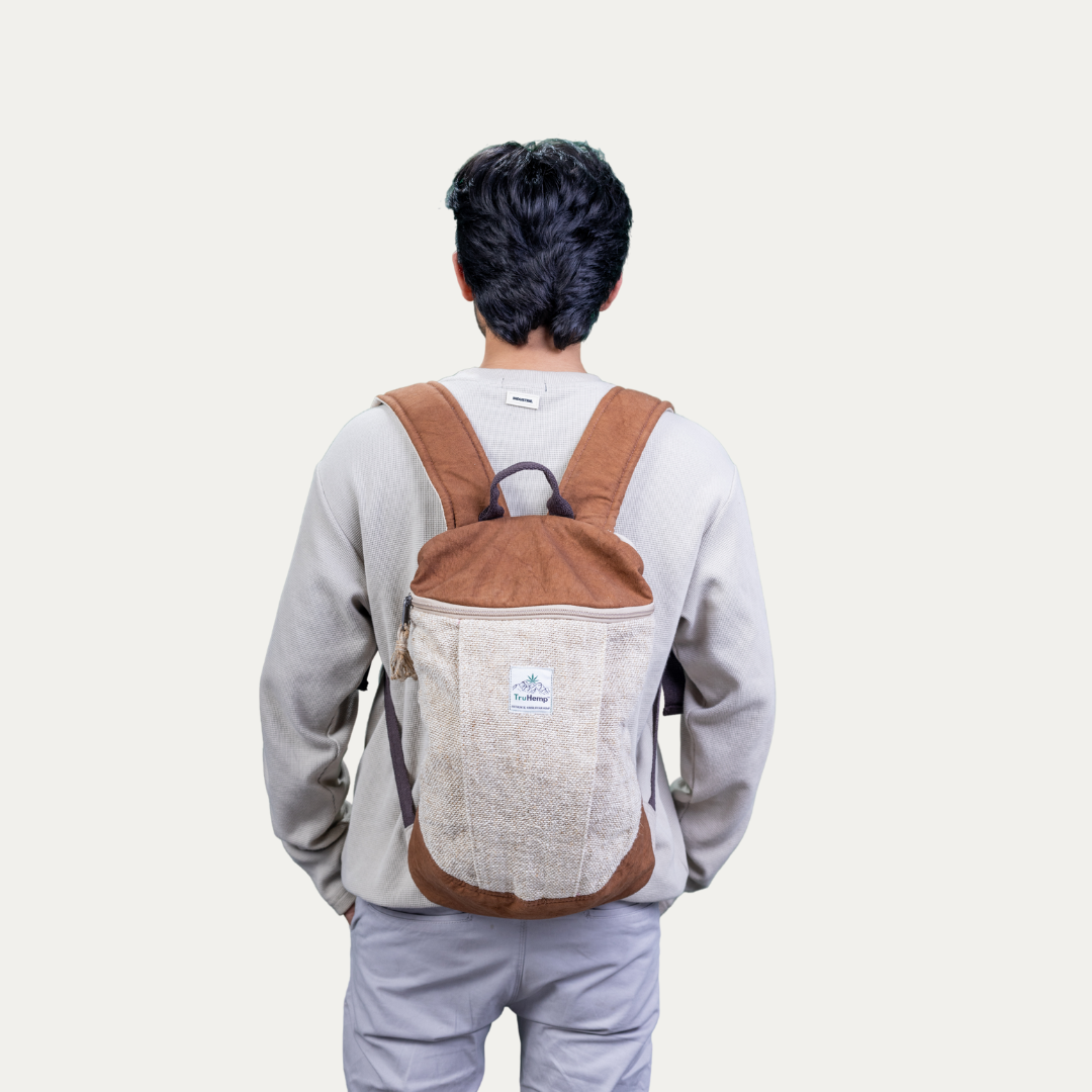 A person wearing a handcrafted hemp backpack with a brown top flap and pure cotton lining.