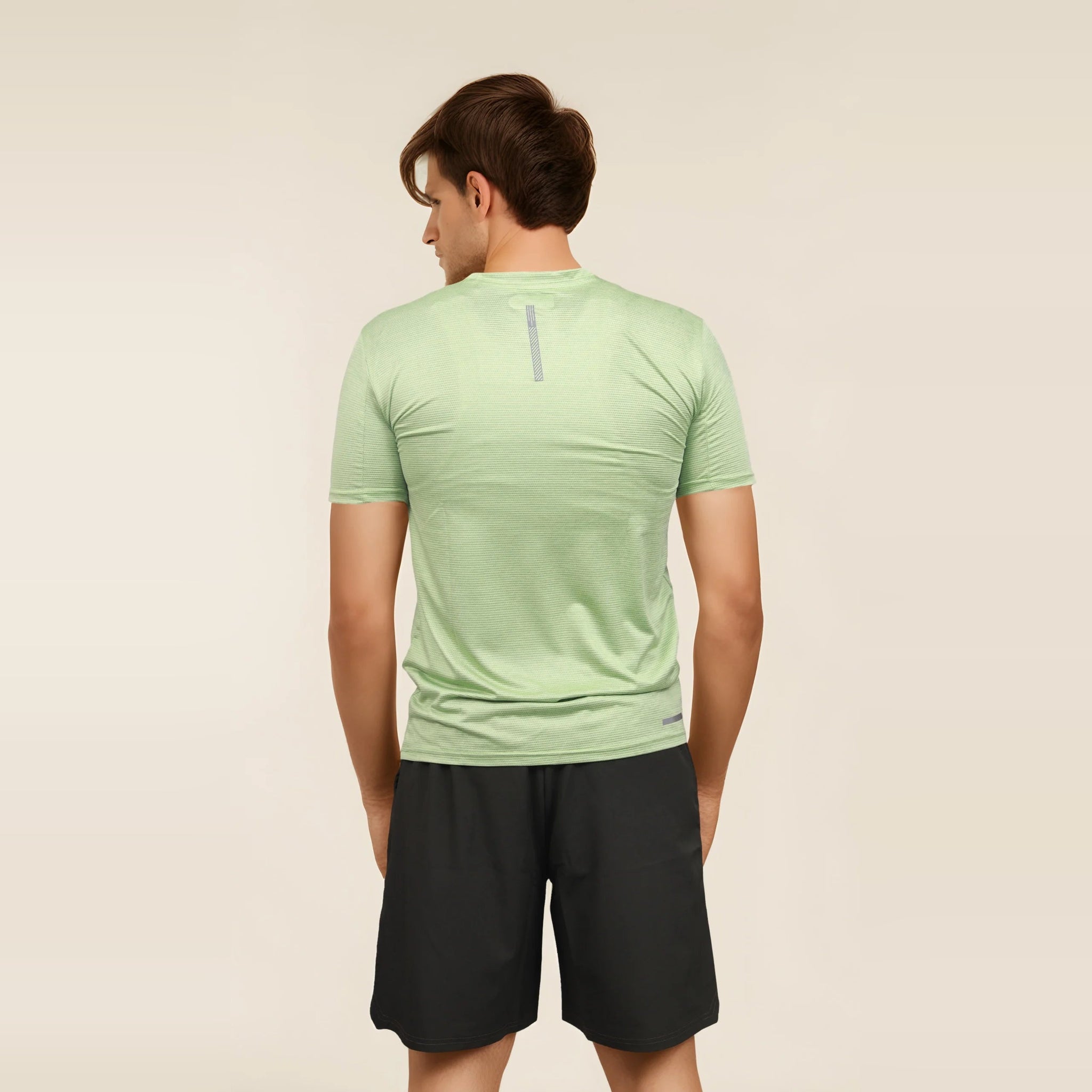 Man wearing a slim-fit, light green, short sleeve men's t-shirt.