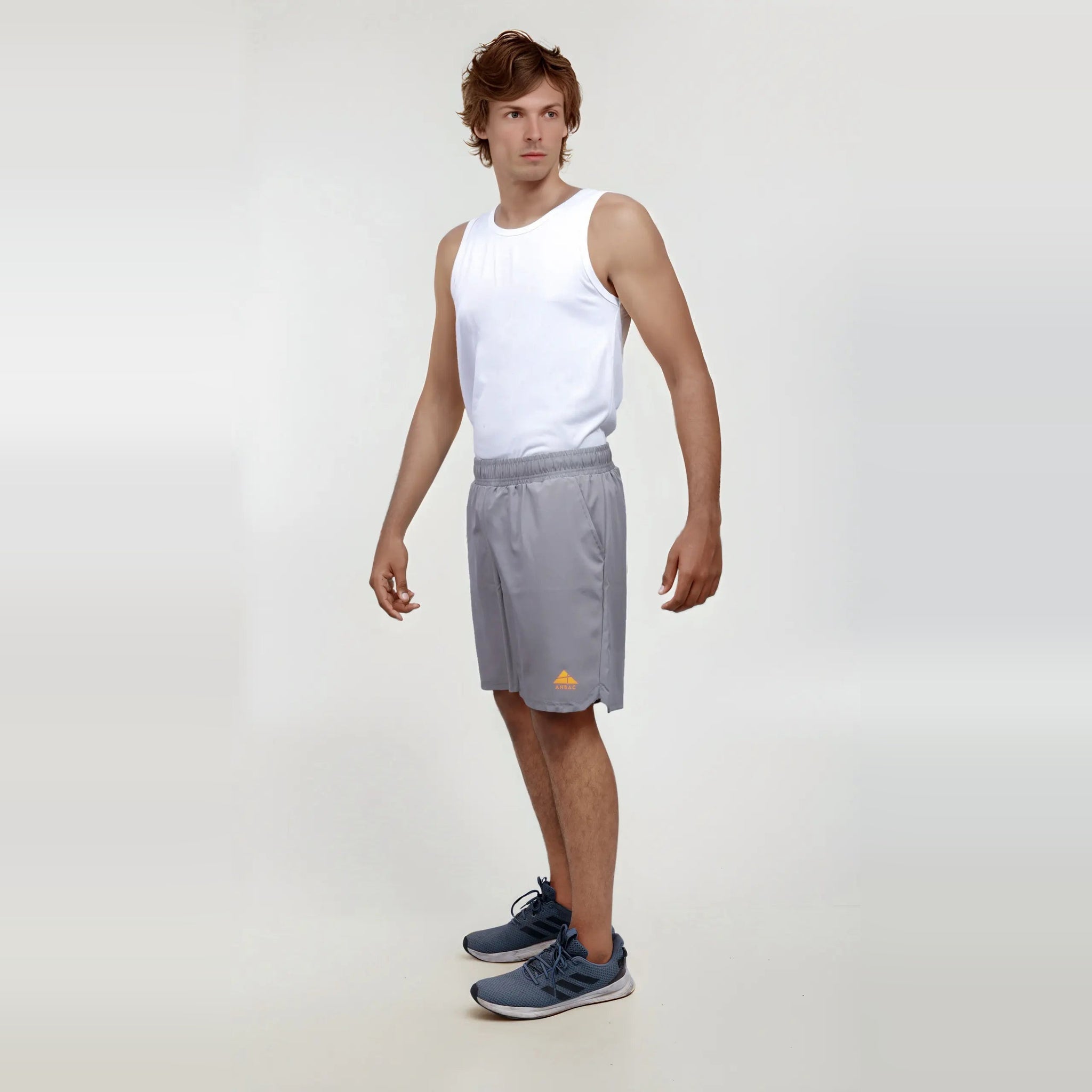 Man modeling gray wrinkle-free, dry-fit shorts for sports and gym.