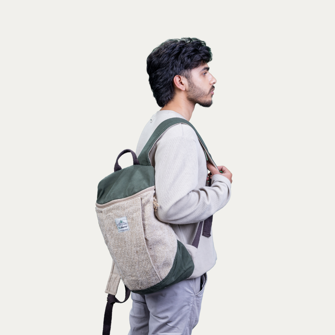 Stylish handcrafted hemp backpack with green canvas and a pure cotton lining, modeled by a person standing sideways.