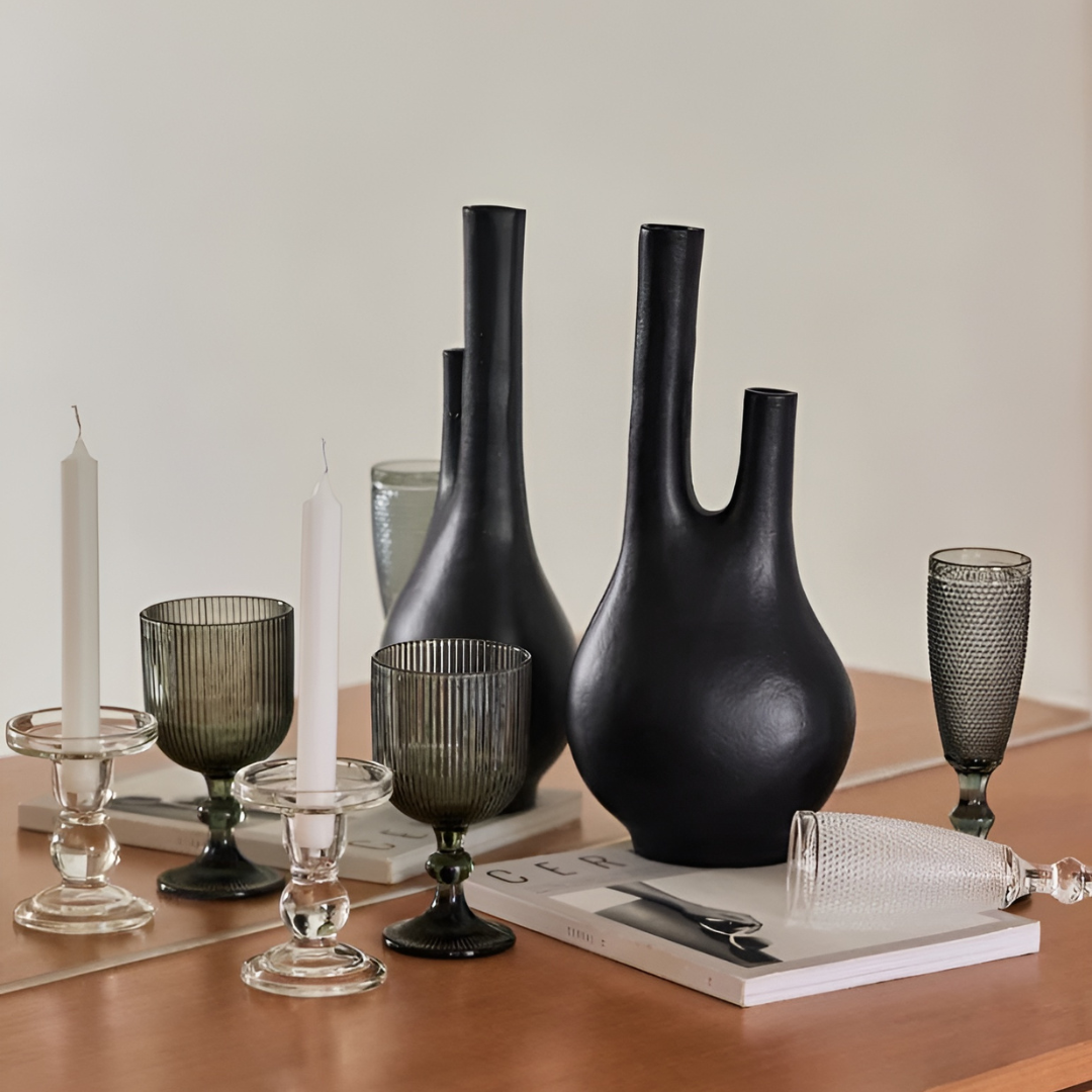 Matte black metal vase with three necks, styled on a tabletop.