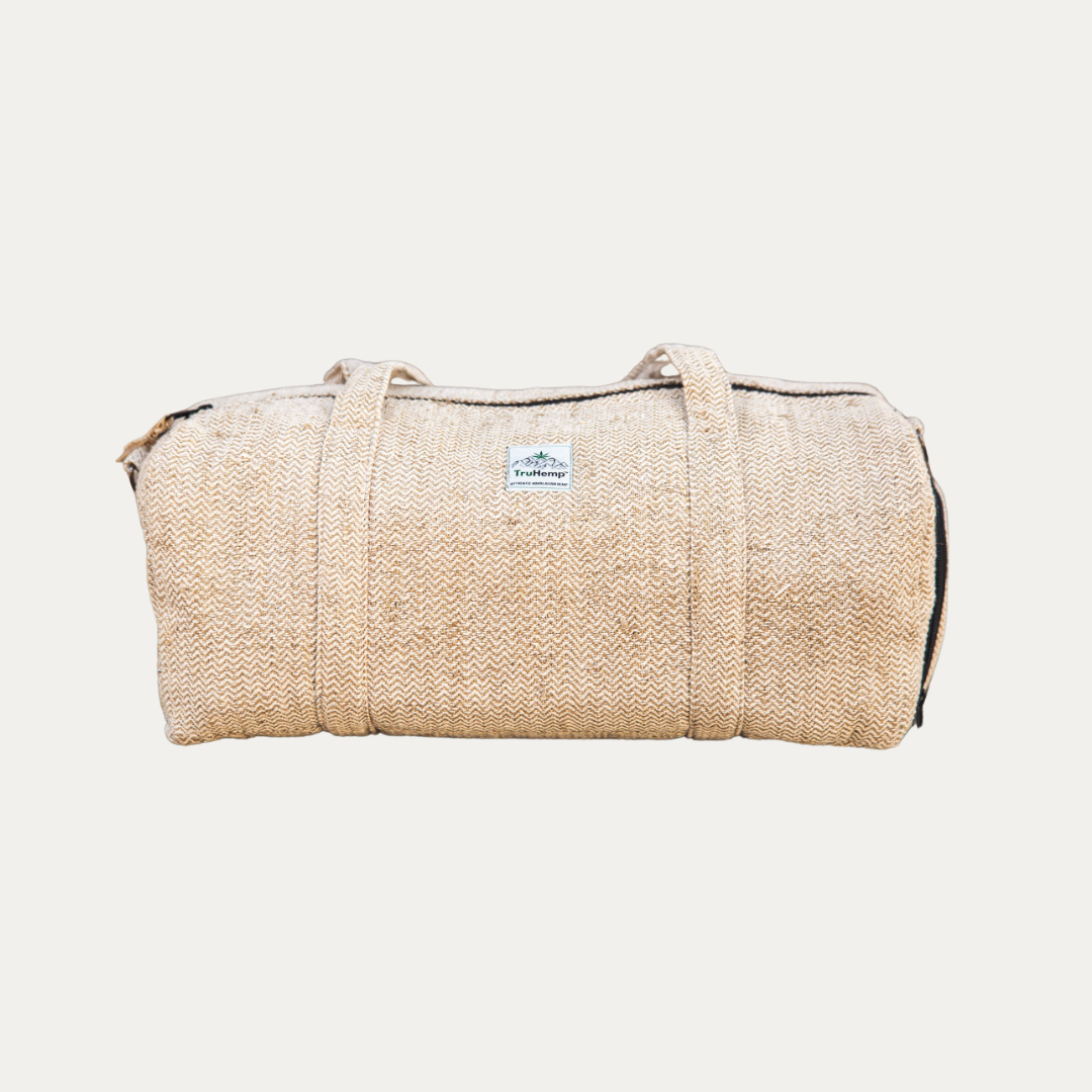 A beige Eco-friendly Hemp Duffle Bag with Shoe Pocket. This sustainable duffle bag is perfect for travel or the gym.